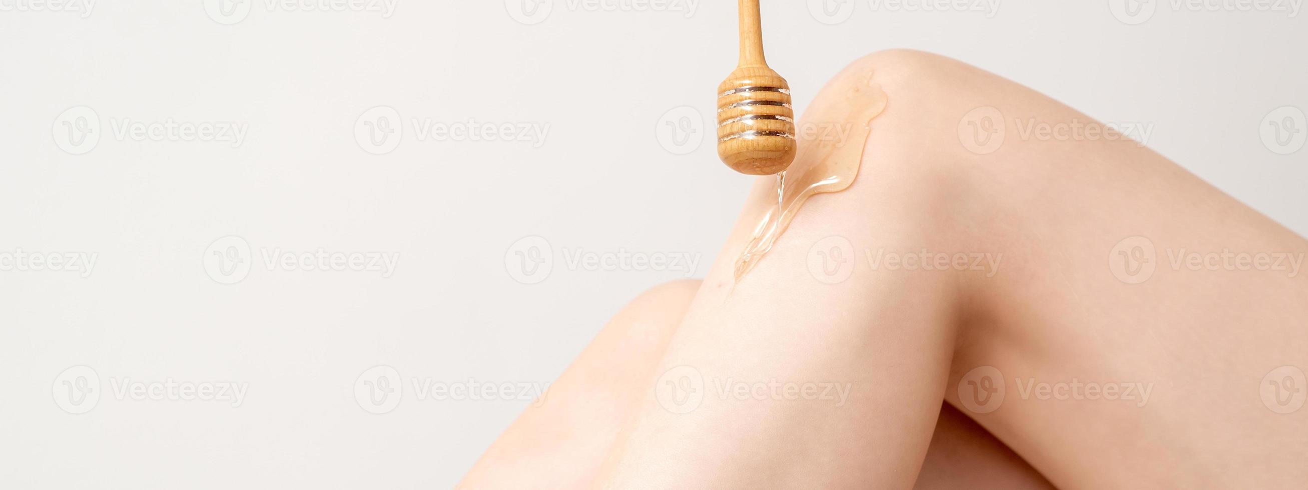 Wax flowing down on female leg photo
