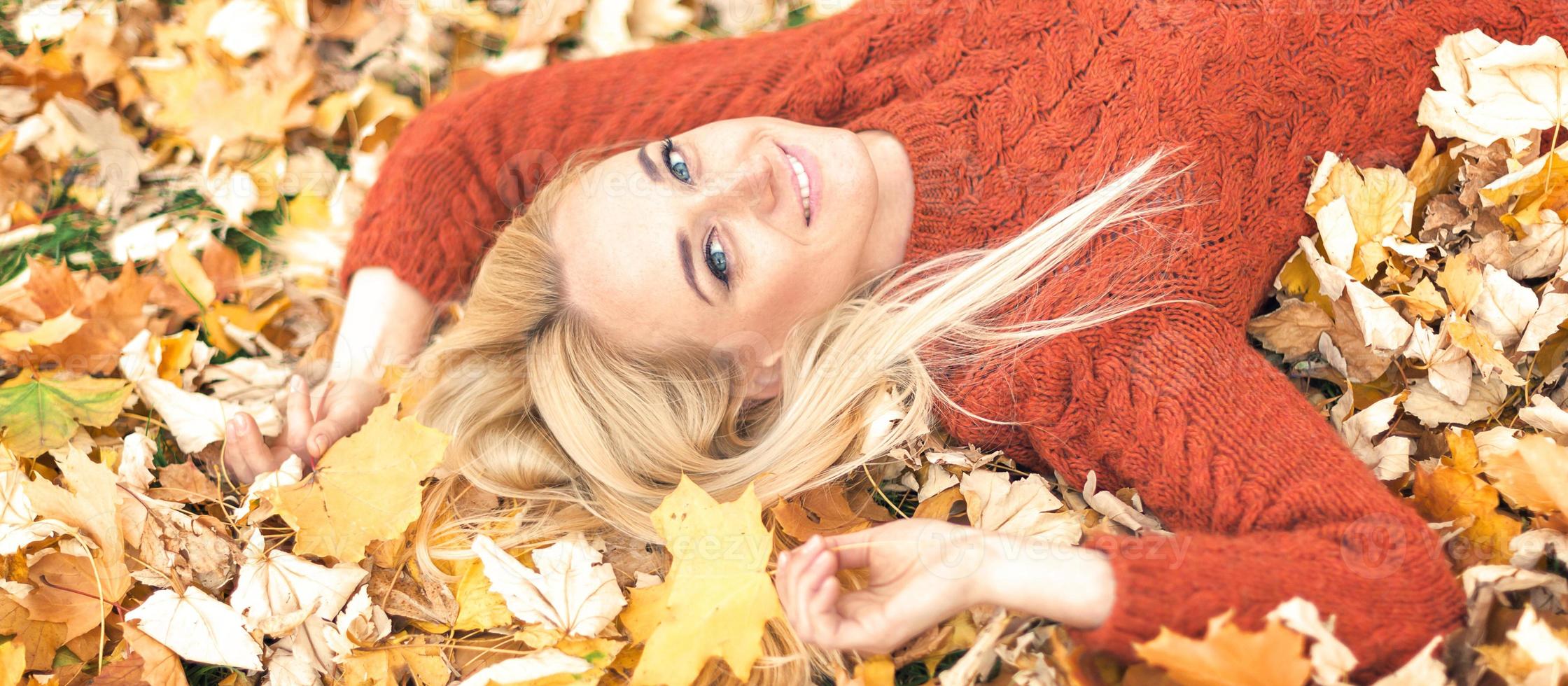 Woman lying down on yellow leaves photo
