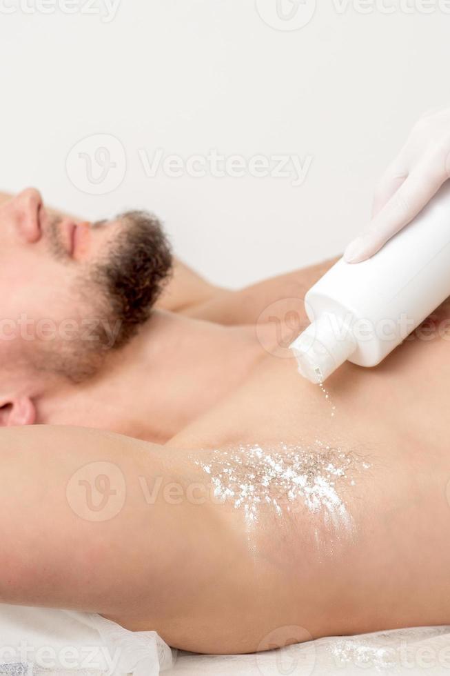 Master depilation pouring talcum powder on armpit photo