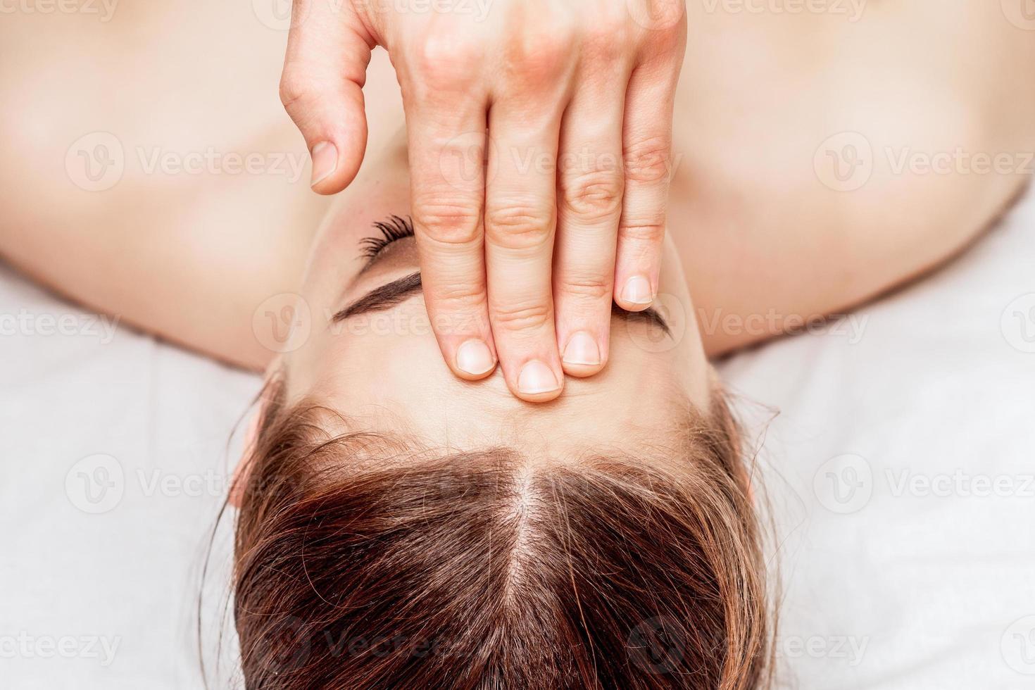 Forehead massage of woman. photo