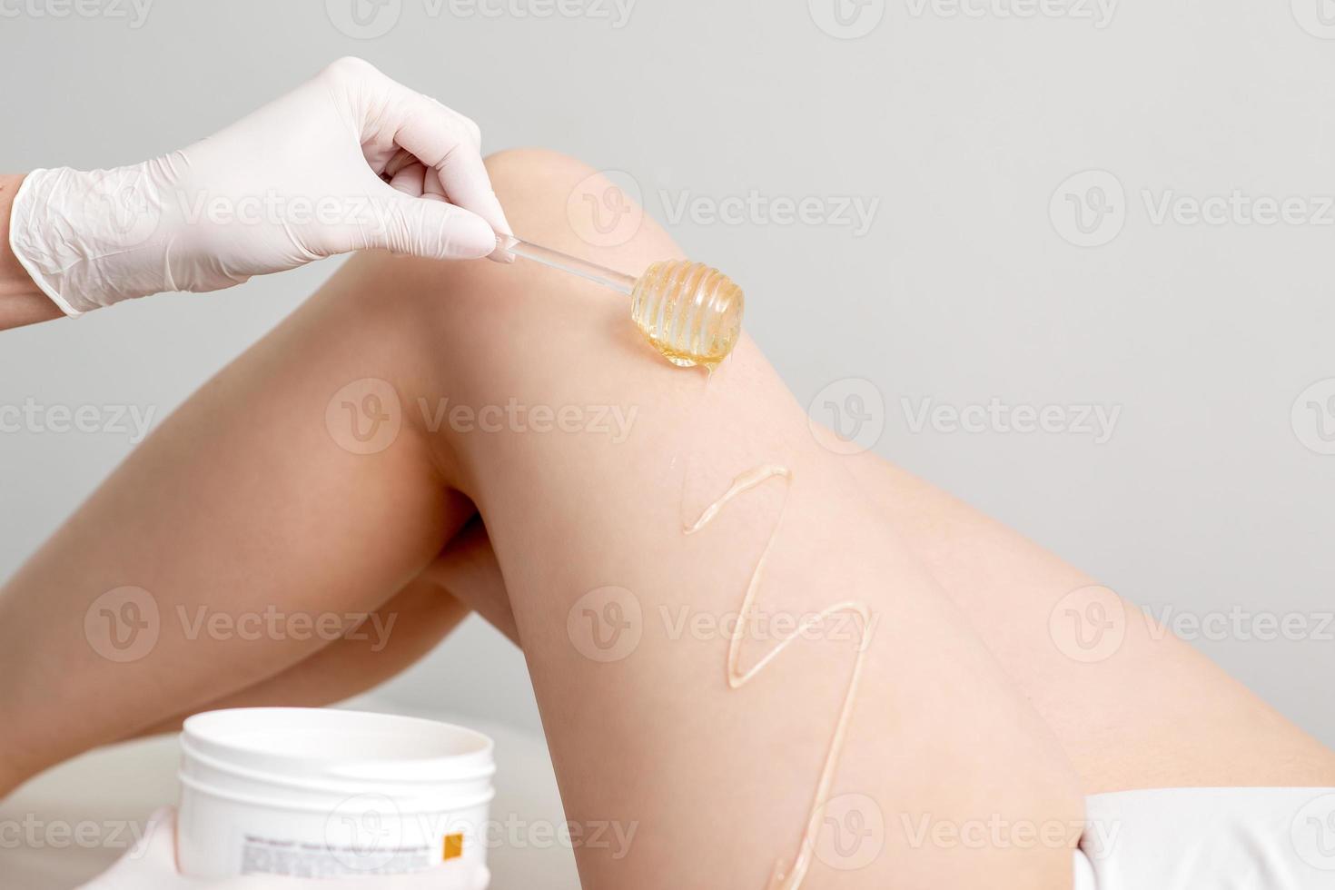 Wax flowing down on female leg photo