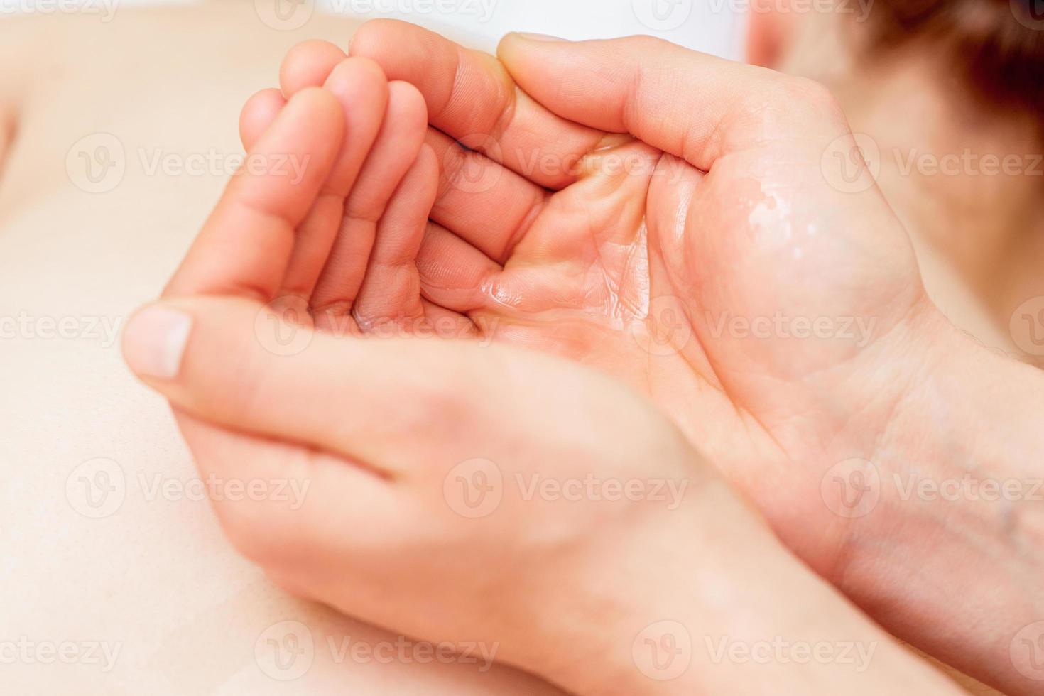 Massage oil in palms of massager. photo