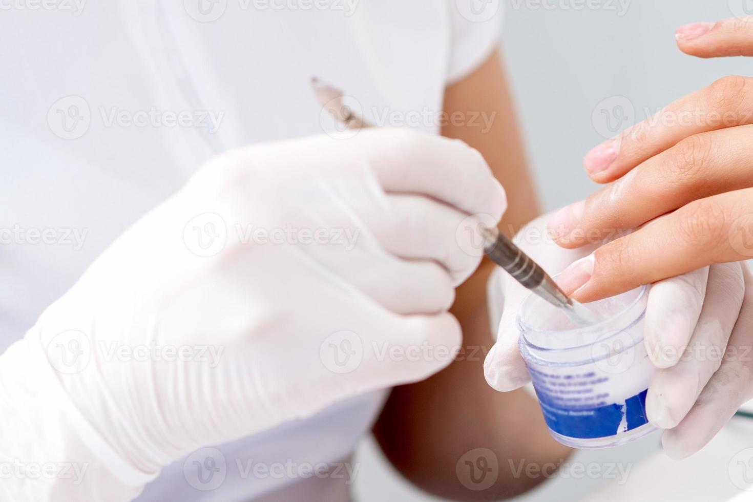 Human hands covering clear varnish on female nails photo