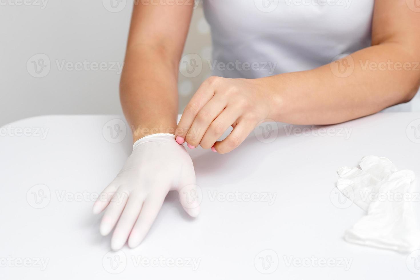 Female hands putting on protective gloves photo