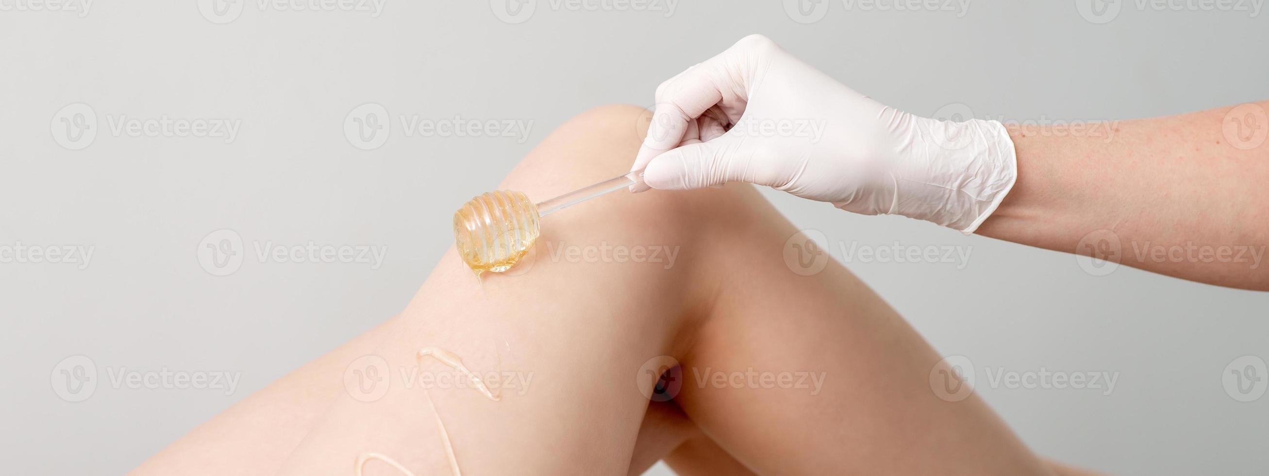 Wax flowing down on female leg photo