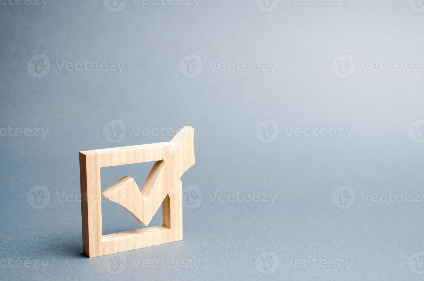 wooden checkmark for voting on elections on a gray background. Presidency or parliamentary elections, a referendum. Survey of the population, statistics, task. Democracy and freedom. Selective focus photo