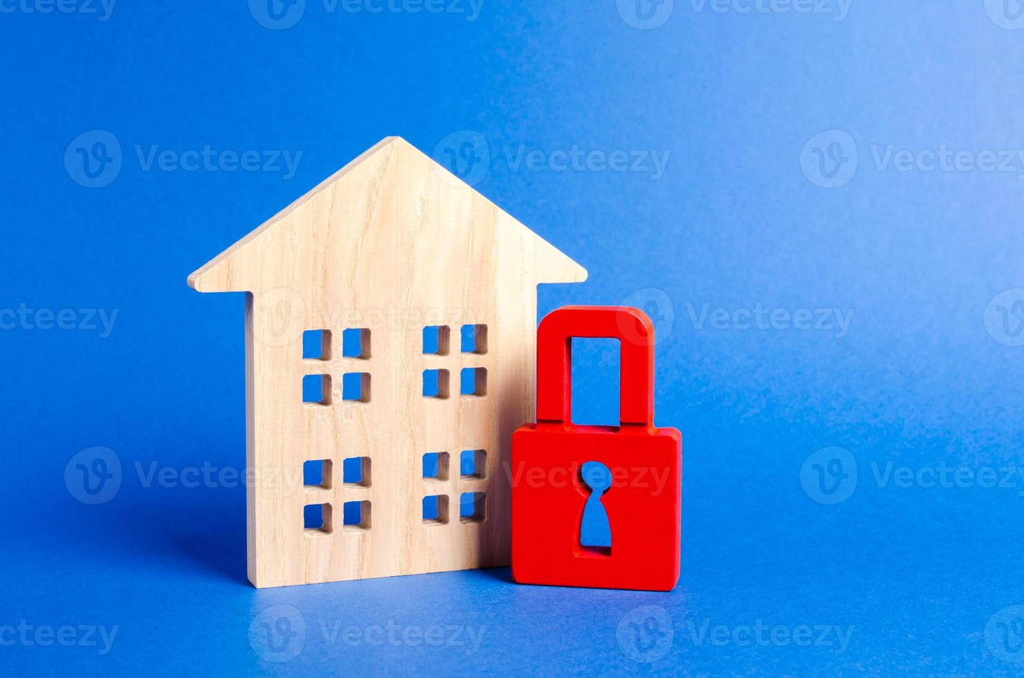 Wooden house and a red padlock. Security and safety. Confiscation for debts. alarm system. seizure of property. Protection of property rights. Unavailable and expensive real estate. house Insurance photo