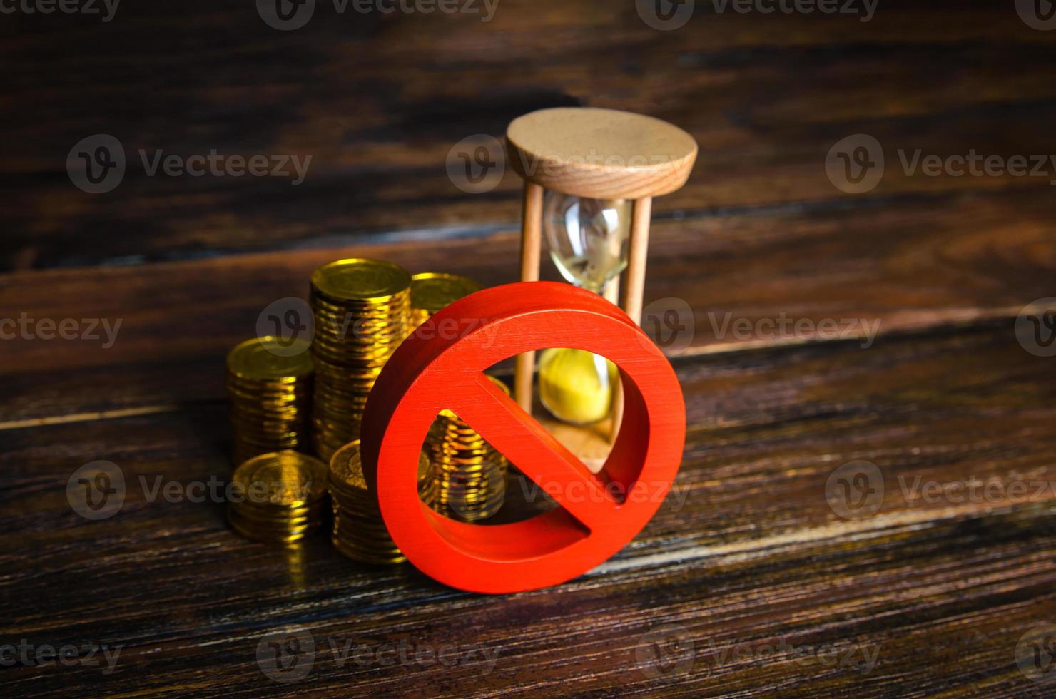 Money and hourglass under the prohibition sign. Sanctions and restrictions. Confiscation of capital of illegal origin. Freezing of assets, seizure of savings. Economic embargo. Loan disapproval. photo