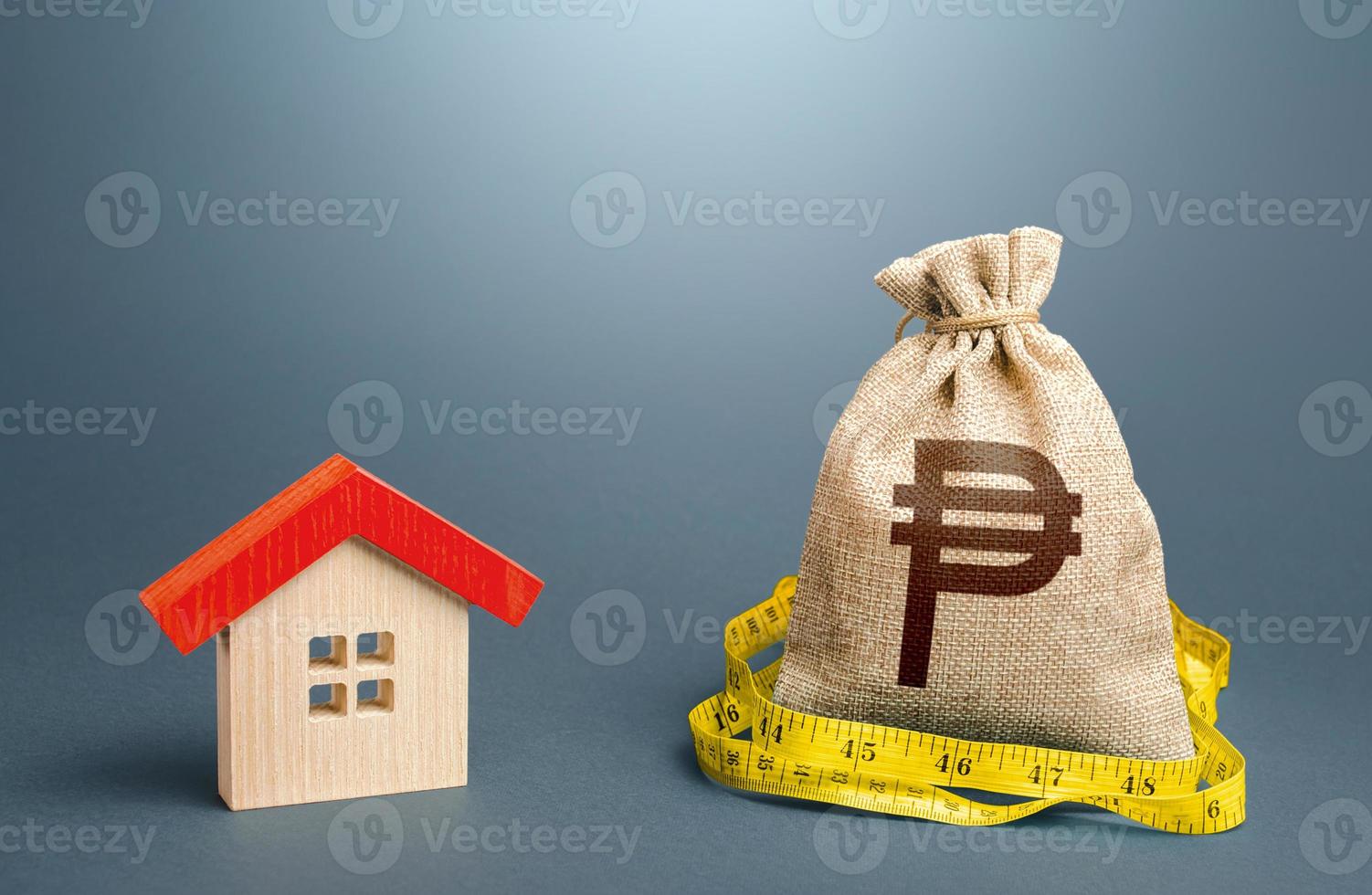 House and a philippine peso money bag. Property real estate valuation. Building maintenance. Mortgage loan. Calculation of expenses for purchase, construction, repair. Buying and selling, fair price. photo