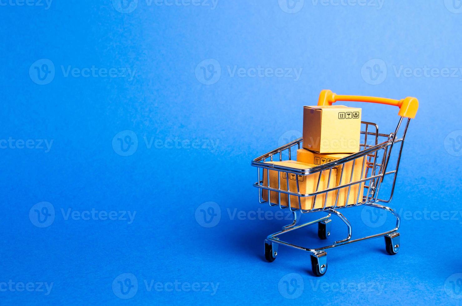 carrito de supermercado con cajas, mercancía. el concepto de compra y venta de bienes y servicios, comercio por Internet, compras en línea, comercio y facturación. importación y exportación, poder adquisitivo. foto