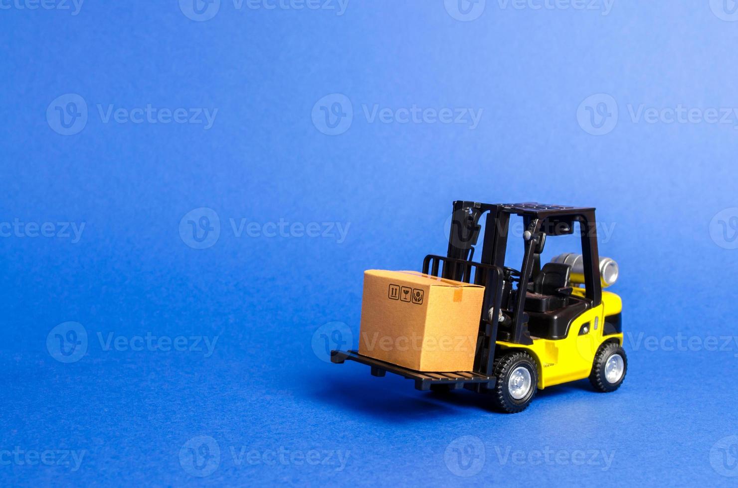 Yellow Forklift truck with cardboard box. Increase sales, production of goods. transportation, storage of cargo. Freight shipping, delivery of goods. logistics industries. retail. copy space photo