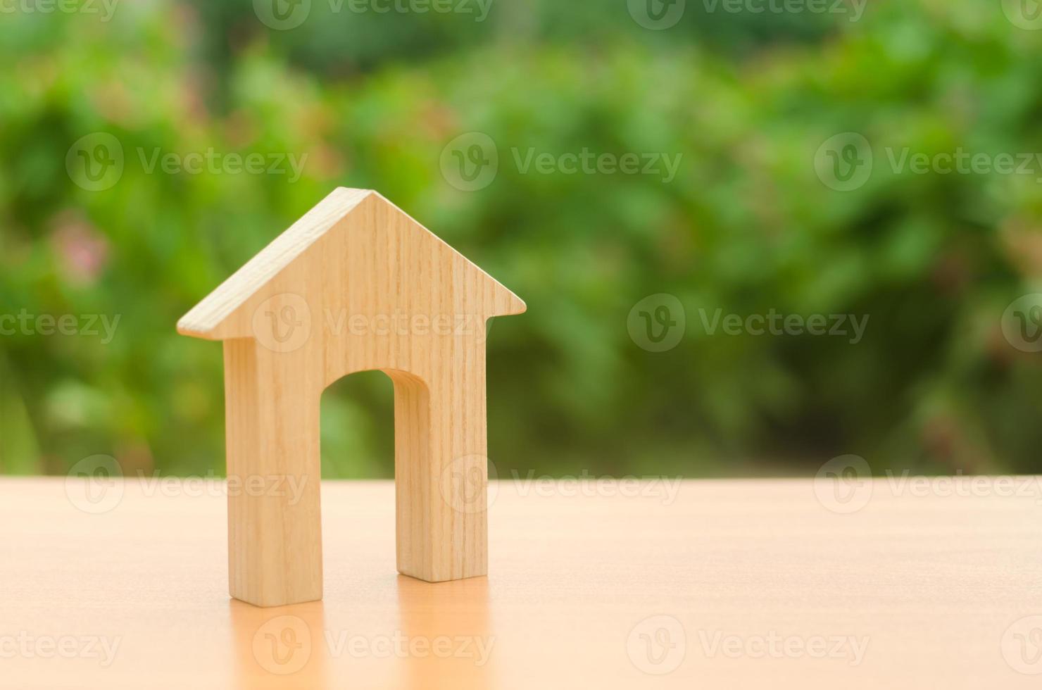 Wooden figure of a house with a large doorway on nature background. Home, Affordable housing, residential building. concept of buying and selling real estate, rent, investment and construction. photo