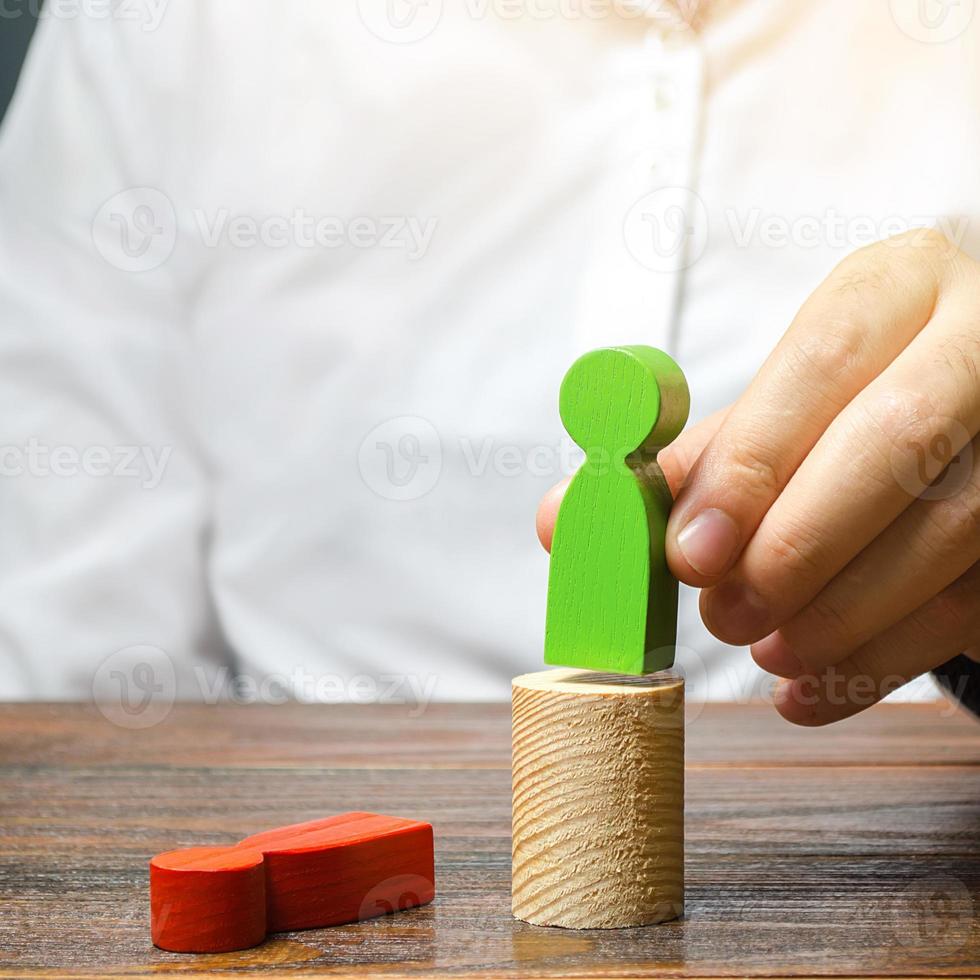 The man changed the red figure to the green one at the post. firing staff. Head Offset. Business optimization, replacement of key employees with loyal ones. Change of power. Anti corruption photo