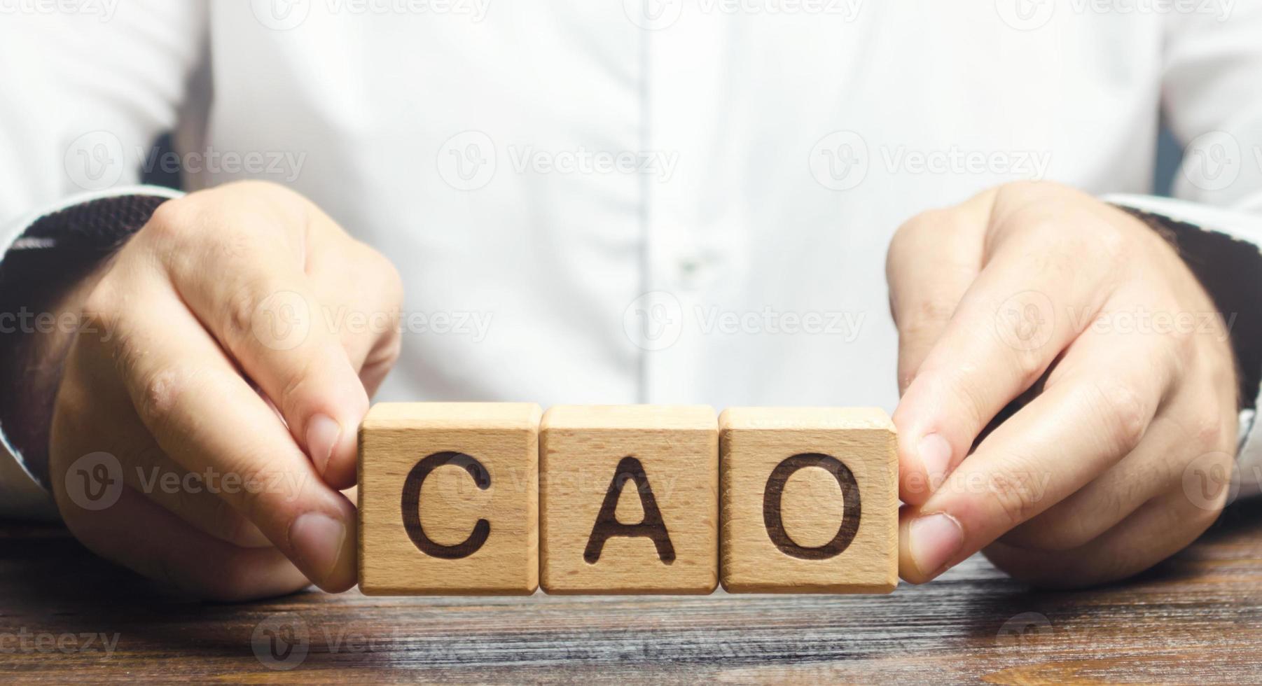 Man holds the word CAO in hands. Manage taxes and payroll. Develop and upgrade finance systems in business. Chief Accounting Officer. Vacancy and duties of a specialist. Financial executives photo