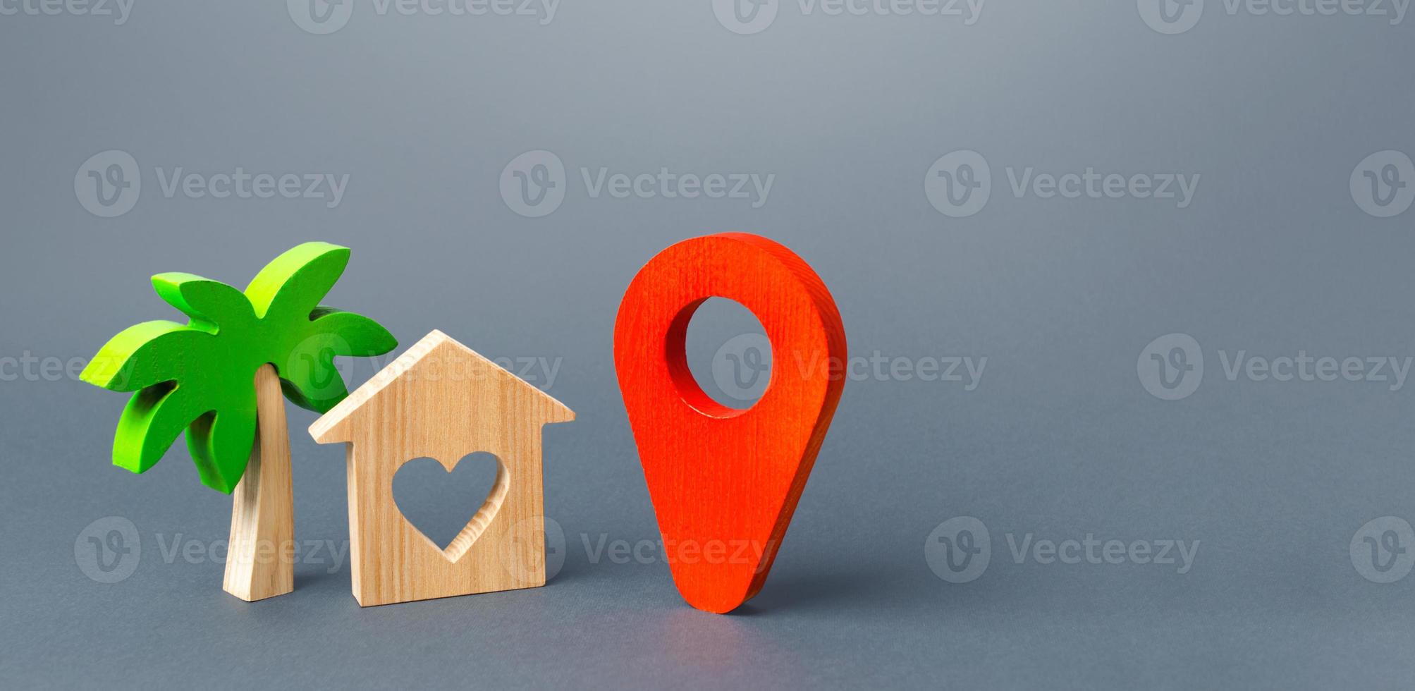 House with a heart and a red navigation pointer pin. Choosing a place for a romantic trip. A tourist guide in the post-pandemic world. New rules for traveling and staying at popular resorts. photo