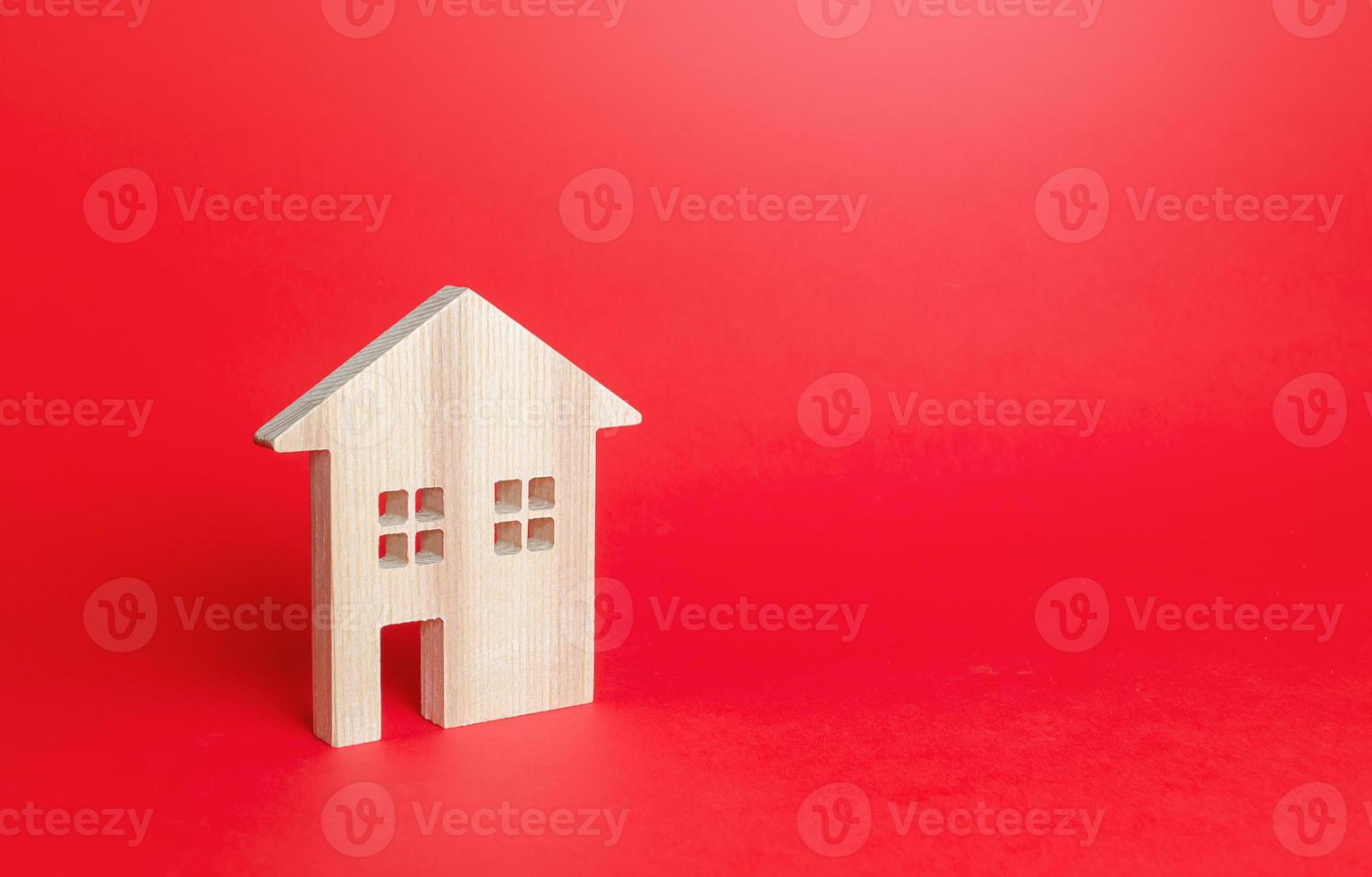 Wooden figurine of a residential building. Minimalism. Affordable housing. Rent of real estate. Construction industry. Realtor services. Utility services. Repair and renovation, modernization. photo