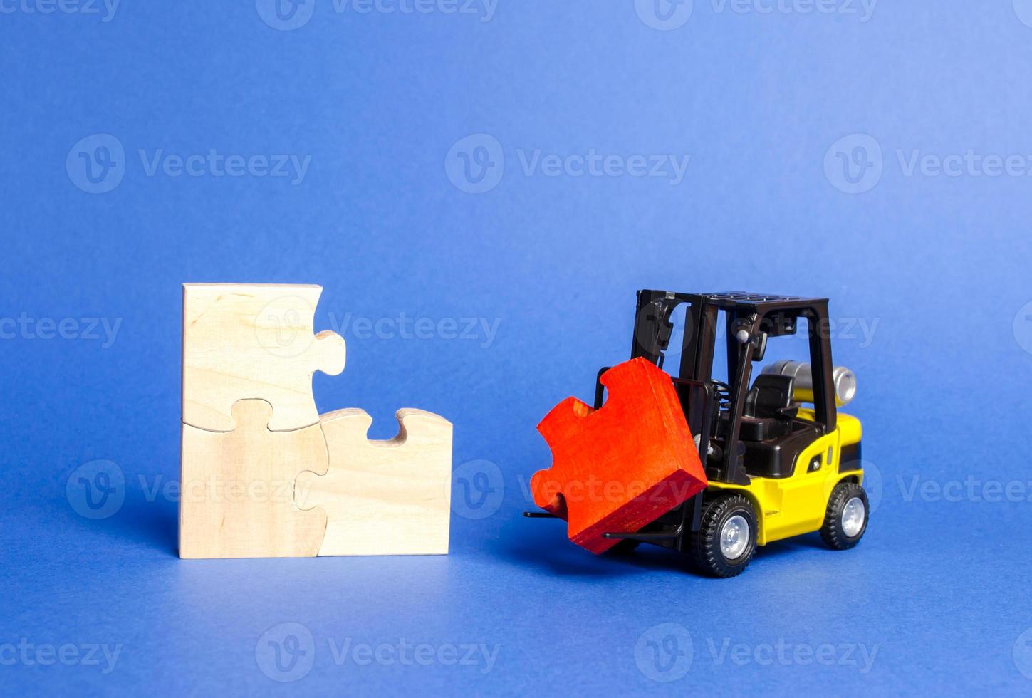 forklift truck brings the missing red puzzle to the unfinished set. construction and completion of the project. Assembly of all components. Attracting investment to the project. Startup, crowdfunding. photo