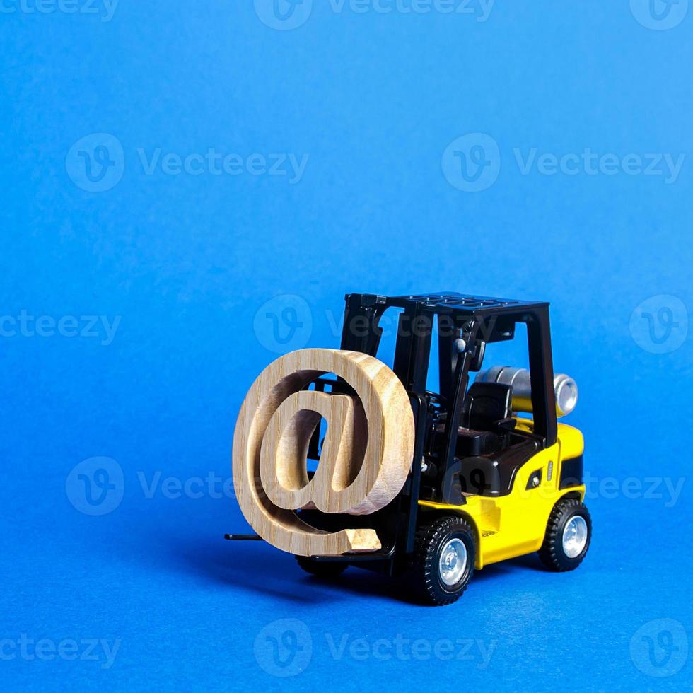 Yellow Forklift truck carry email symbol commercial AT. Integration of the industry into network technologies and Internet. E-commerce. sales of goods through online trading platforms. shopping online photo