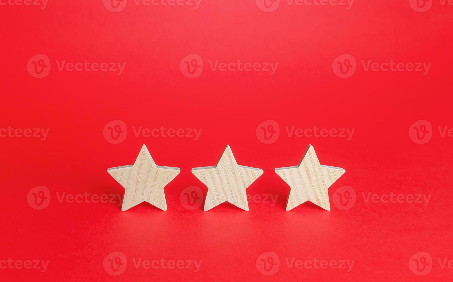 Three stars on a red background. Rating evaluation concept. Service quality. Buyer feedback. High satisfaction. Good reputation status. Popularity rating of a restaurant, hotel or mobile applications. photo