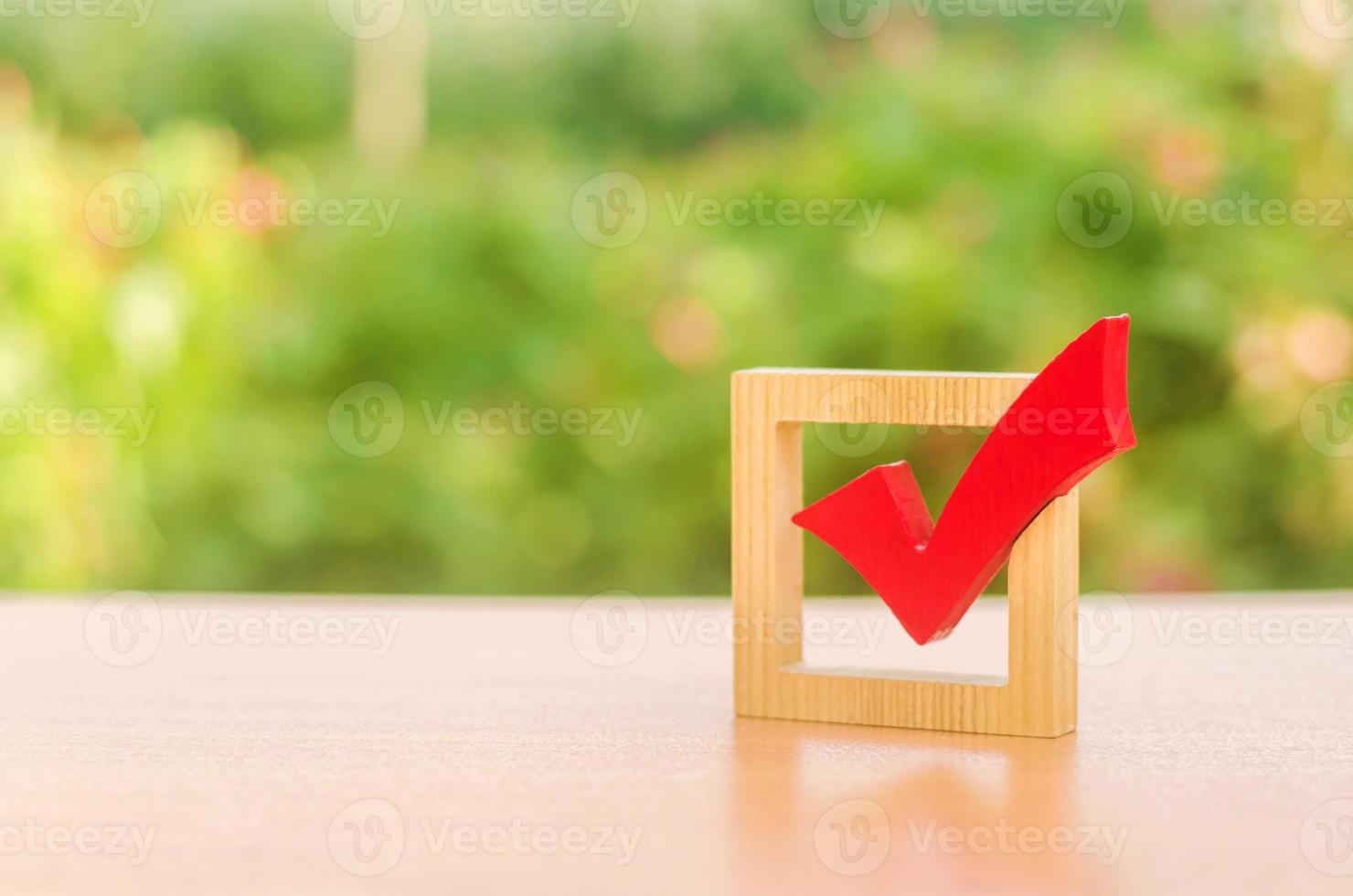 Red wooden checkmark for voting on elections. Presidency or parliamentary elections, a referendum. Survey of the population, statistics, task. Democracy and freedom. Life plans and goals. To do list photo