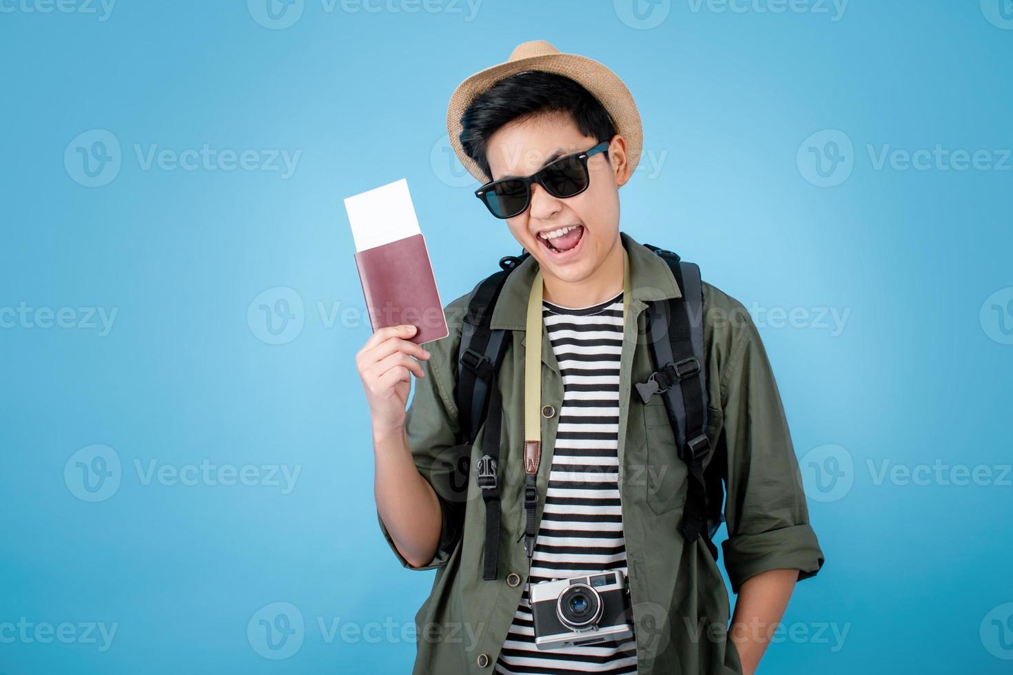 Asian tourists are enjoying his holiday while holding a passport book on a blue background in the studio. photo