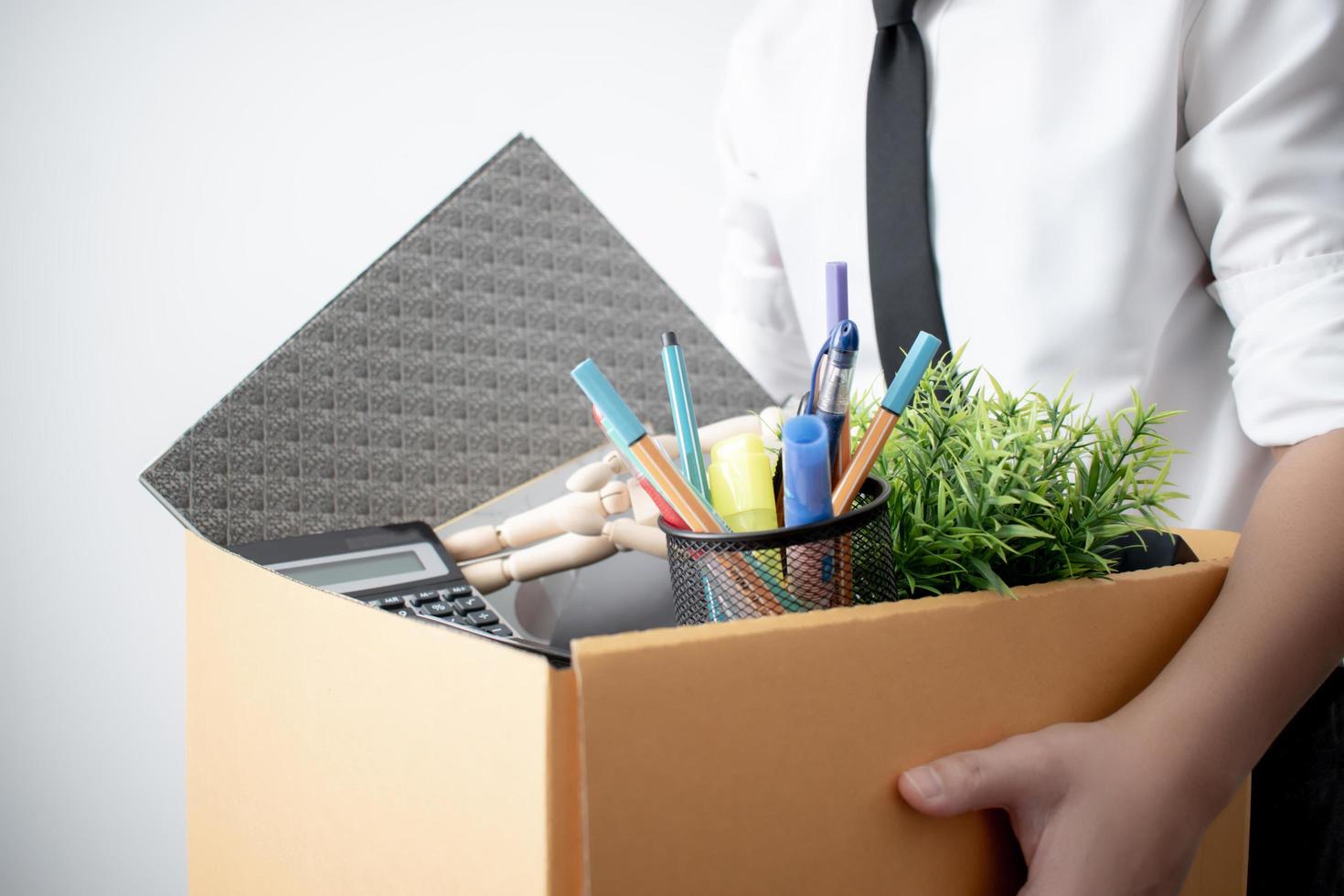 Fired from work. The picture of a business man with a box on a white background. photo