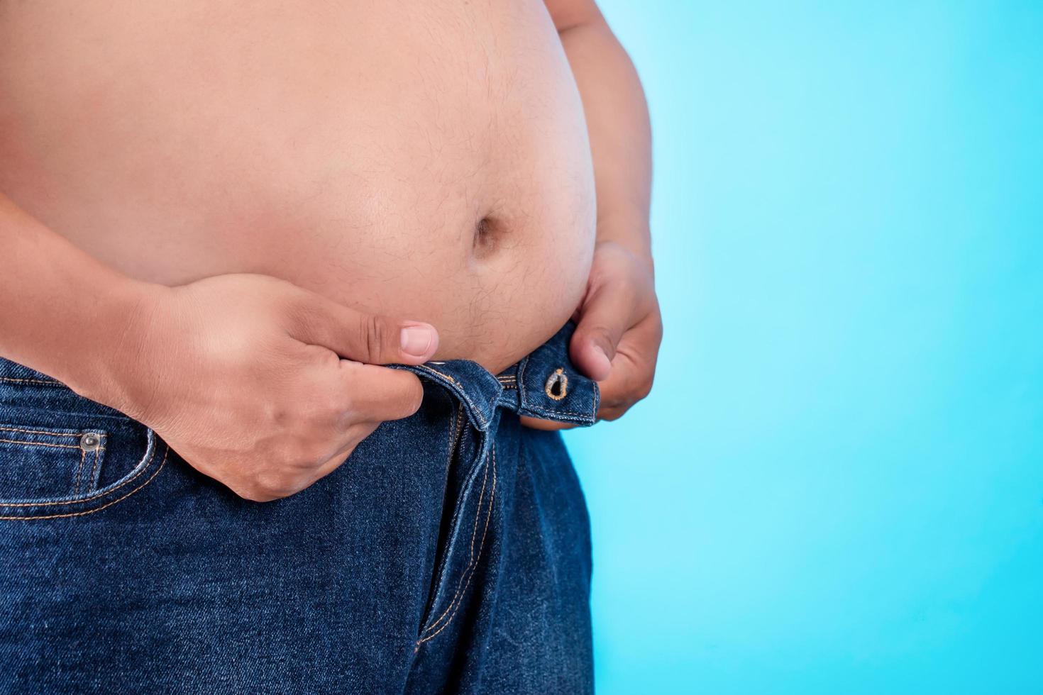 los hombres con sobrepeso usan jeans demasiado pequeños. conceptos de obesidad foto