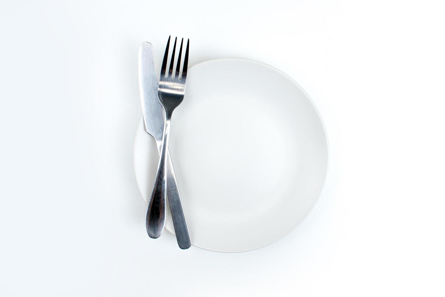 una cuchara y un tenedor en un plato blanco foto