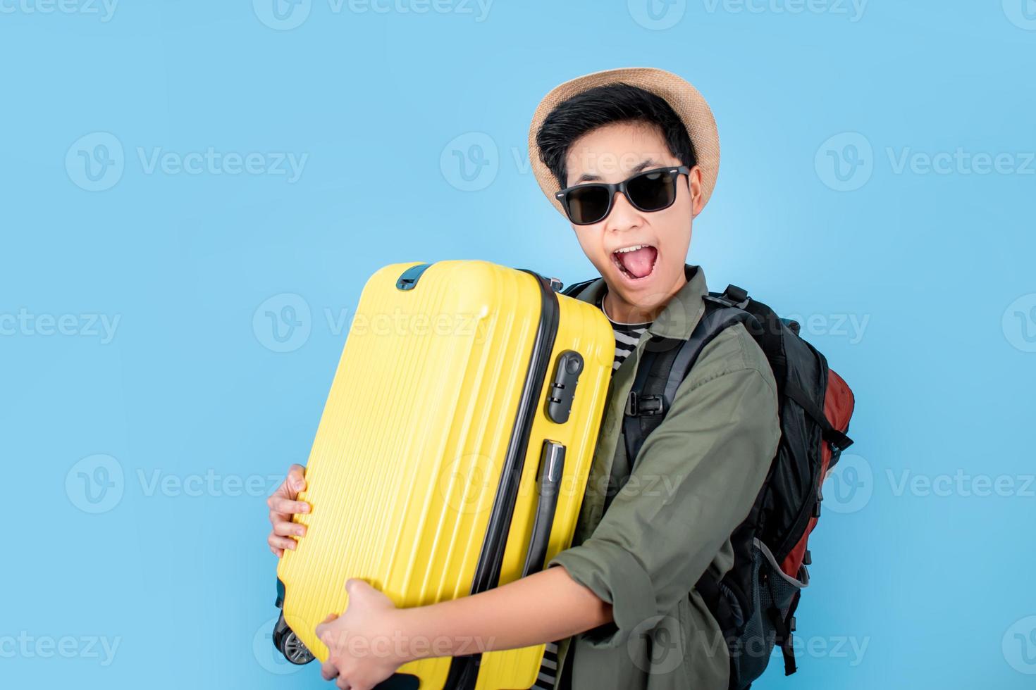 los turistas son felices y sonrientes con una maleta amarilla en la bolsa de fondo azul. foto