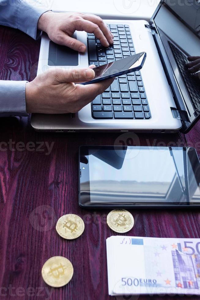 Laptop with cash and bitcoin photo
