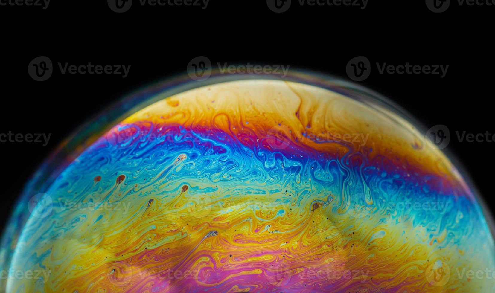 Virtual reality space with abstract multicolor psychedelic planet. Closeup Soap bubble like an alien planet on black background photo