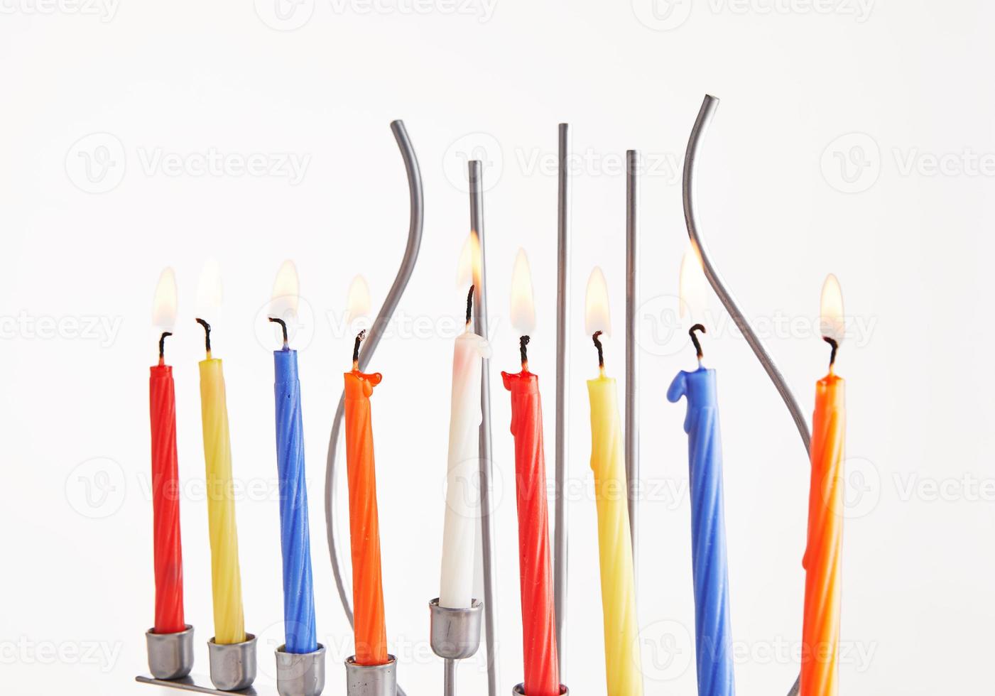 Jewish holiday Hanukkah background. Traditional dish is sweet donuts. Hanukkah table setting candlestick with candles and spinning tops on white background. Lighting Chanukah candles. Copy space photo