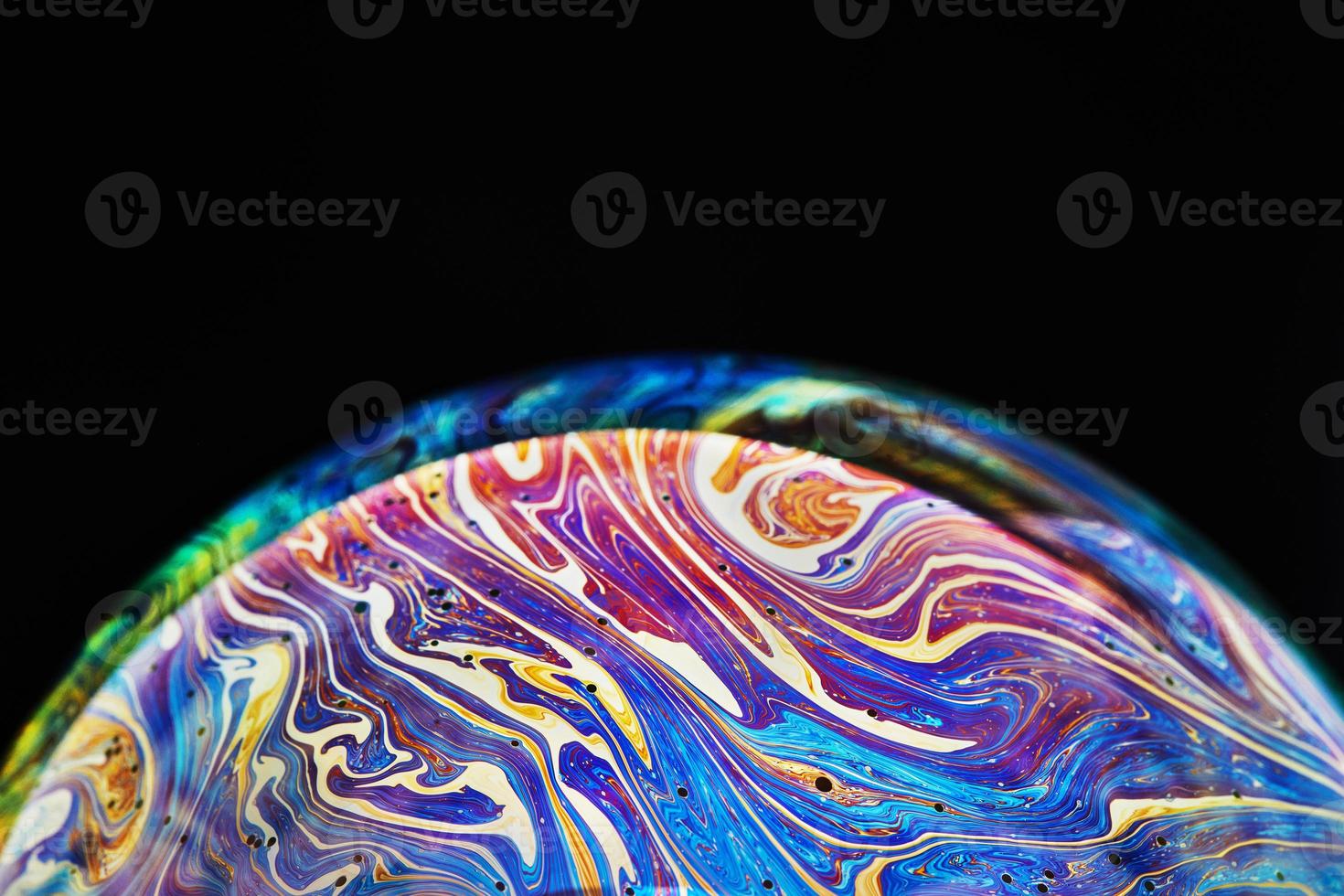Virtual reality space with abstract multicolor psychedelic planet. Closeup Soap bubble like an alien planet on black background photo