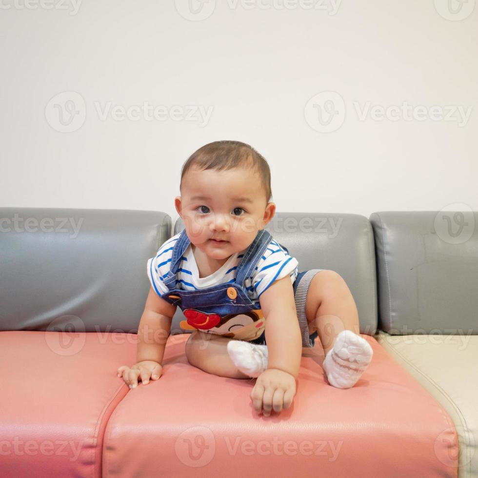 niño sentado y jugando con un juguete sonriendo luciendo lindo centrándose solo en el niño en el centro de la imagen hay un ligero desenfoque en el área circundante destinado a proporcionar imágenes con profundidad foto