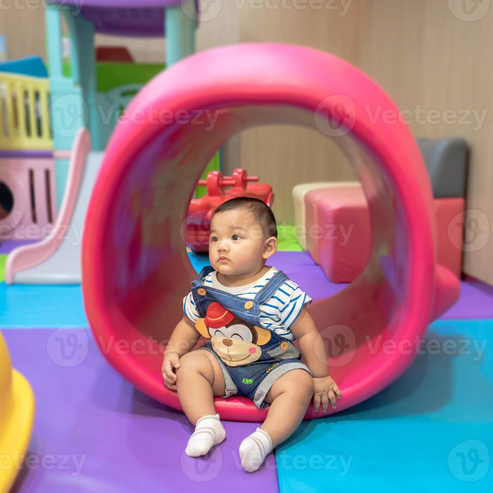 Child sitting and playing with toy smiling looking cute Focusing only on the child in the center of the picture There is a slight blur in the surrounding area intended to provide images with depth photo