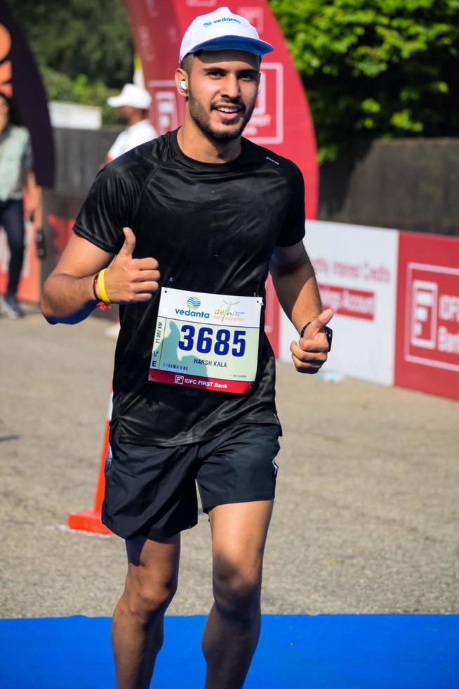 nueva delhi, india - 16 de octubre de 2022 - carrera de media maratón de vedanta delhi después de covid en la que los participantes del maratón están a punto de cruzar la línea de meta, media maratón de delhi 2022 foto