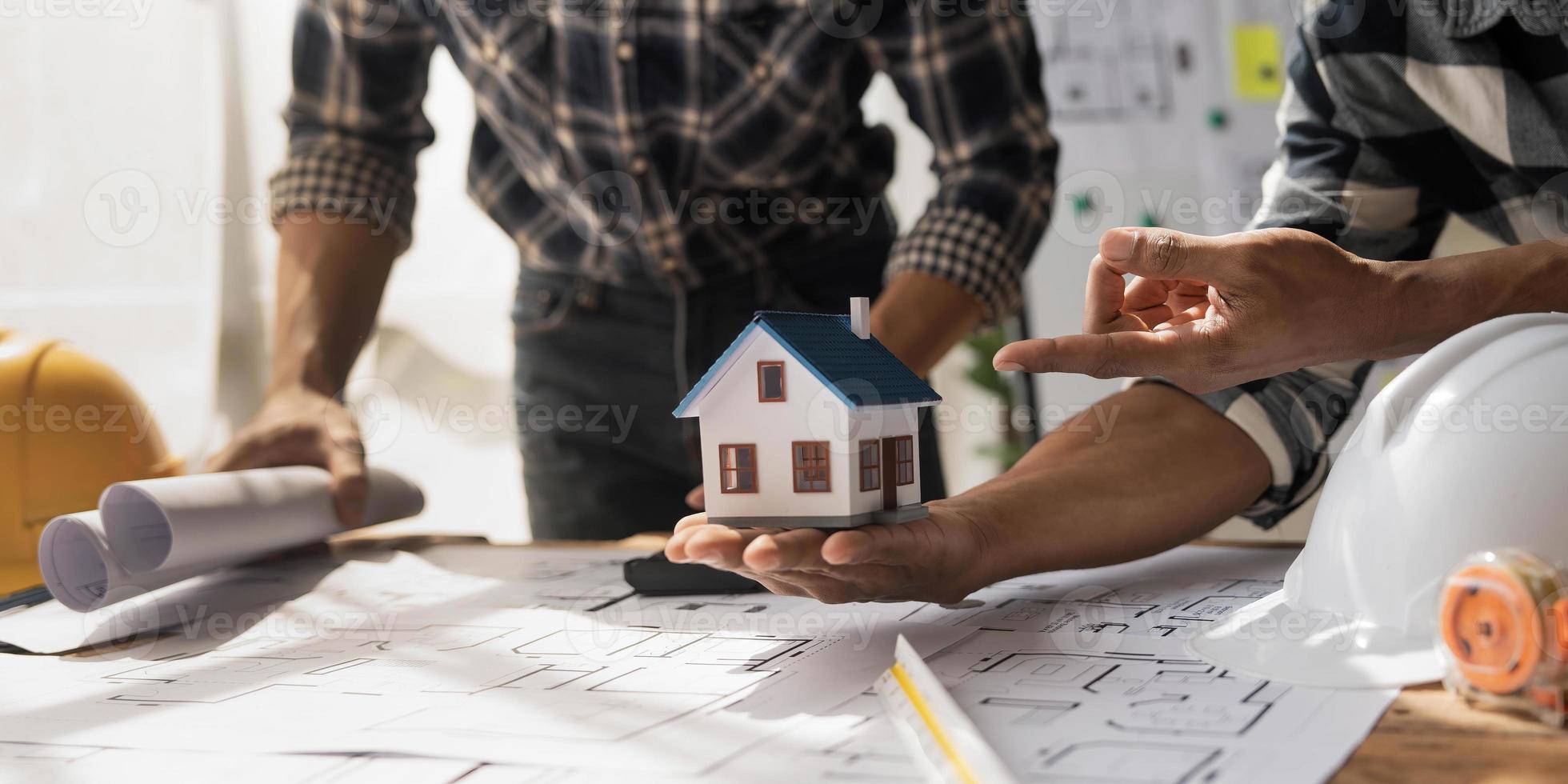 Concept architects, engineer holding pen pointing equipment architects On the desk with a blueprint in the office, Vintage, Sunset light.Selective Focus photo