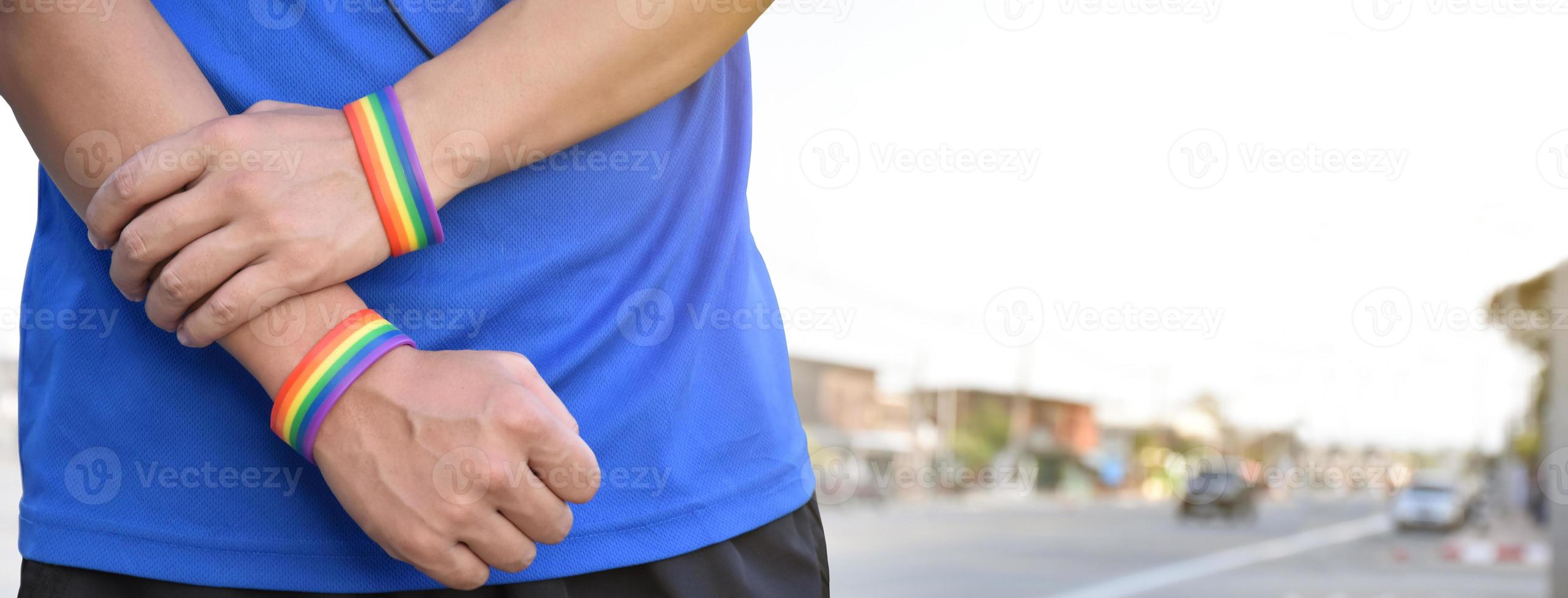 Rainbow wristband on right and left hand, soft and selective focus photo