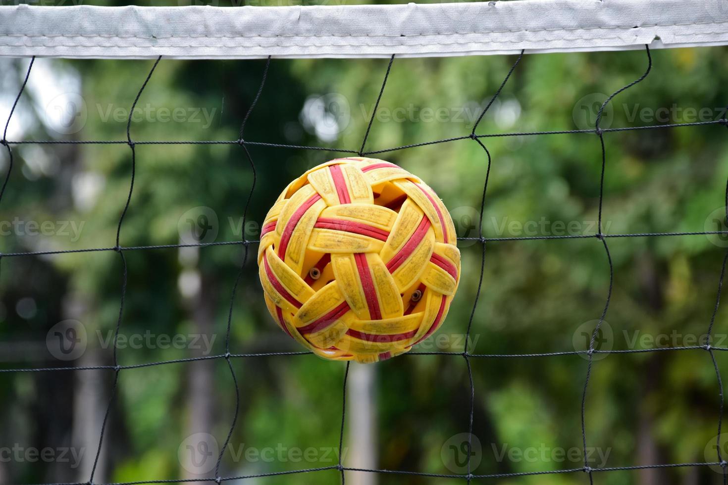 Sepak takraw ball on net, soft and selective focus on ball, outdoor sepak takraw playing after school and after work concept. photo