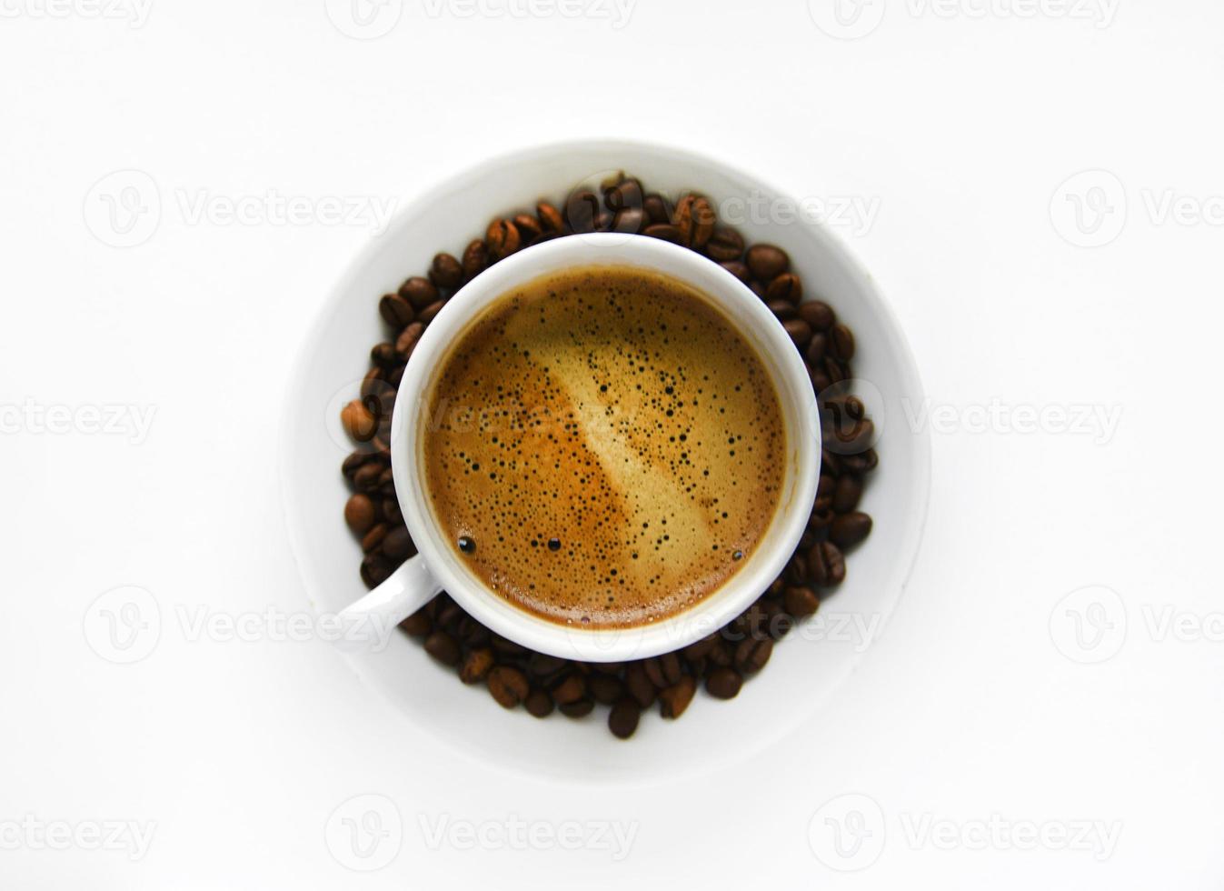 White porcelain cup with coffee and coffee beans on a white background. Tea pair with foamy coffee and coffee beans. photo