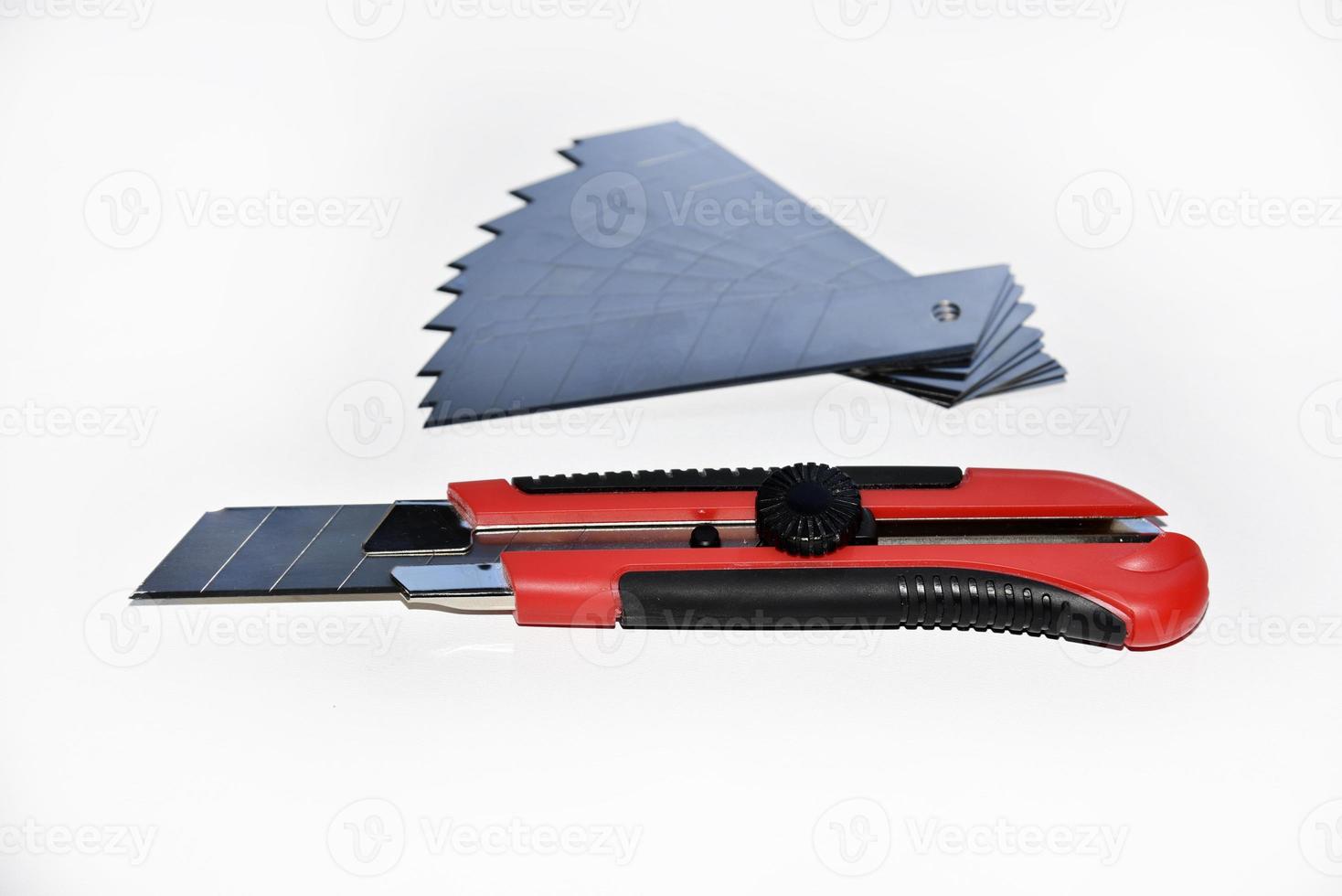 Red stationery knife with blades on a white background. Cutting tool with blades on a white background. photo