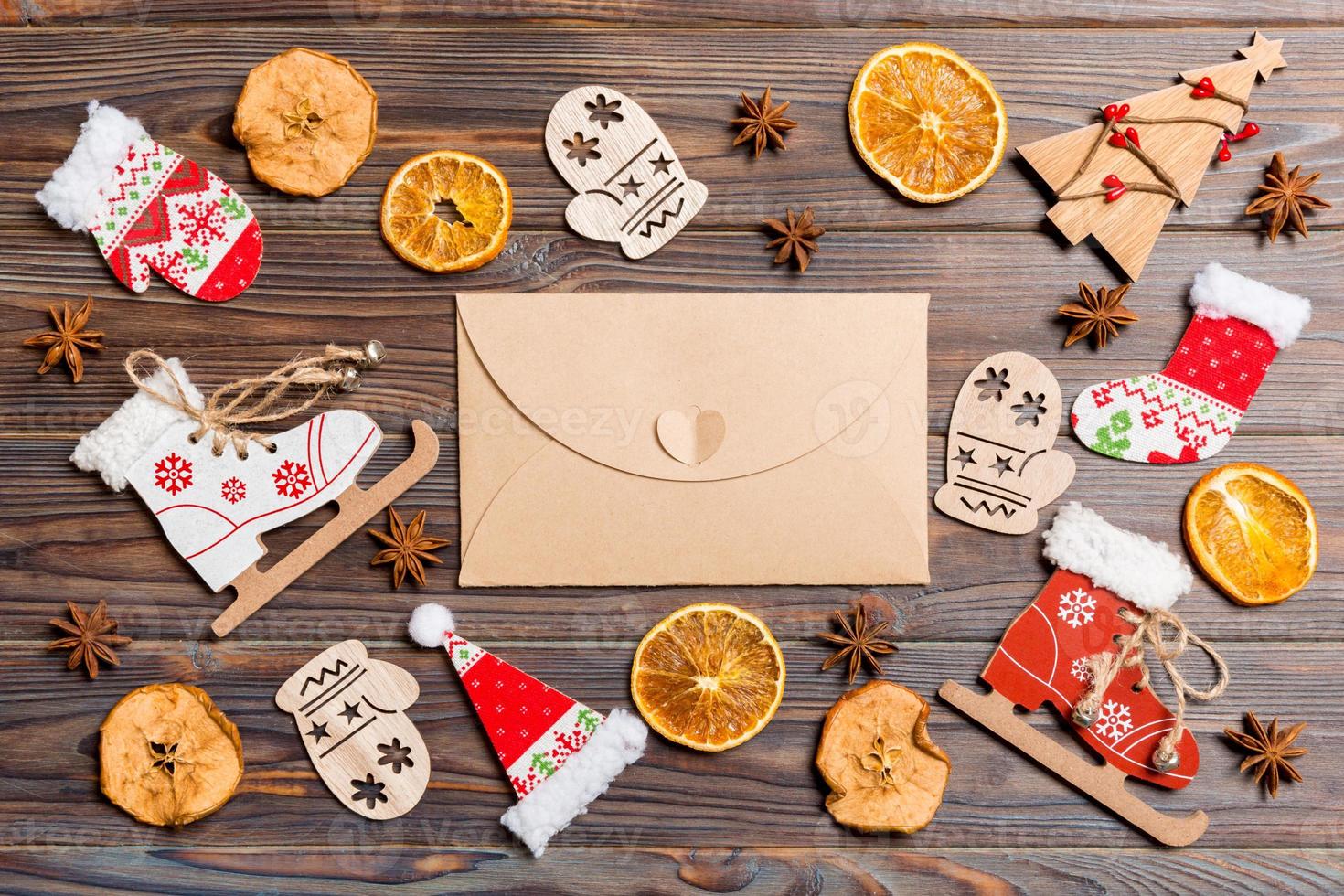 Top view of envelope on festive wooden background. Christmas toys and decorations. New Year time concept photo