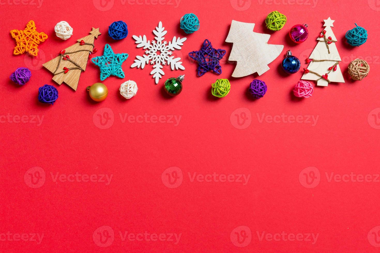 Top view of holiday decorations and toys on red background. Christmas ornament concept with empty space for your design photo