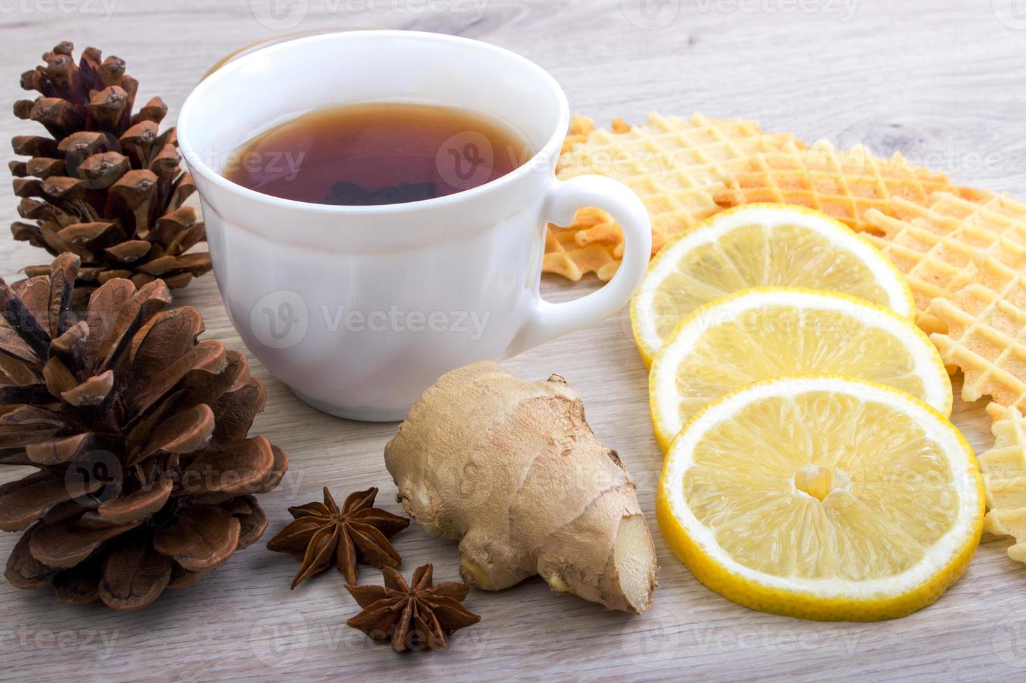 Cup of tea with pinecone, badian, ginger, waffles and cinnamon photo