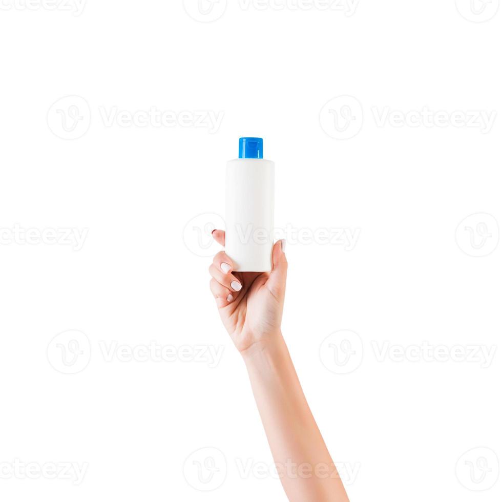 Female hand holding cream bottle of lotion isolated. Girl give tube cosmetic products on white background photo