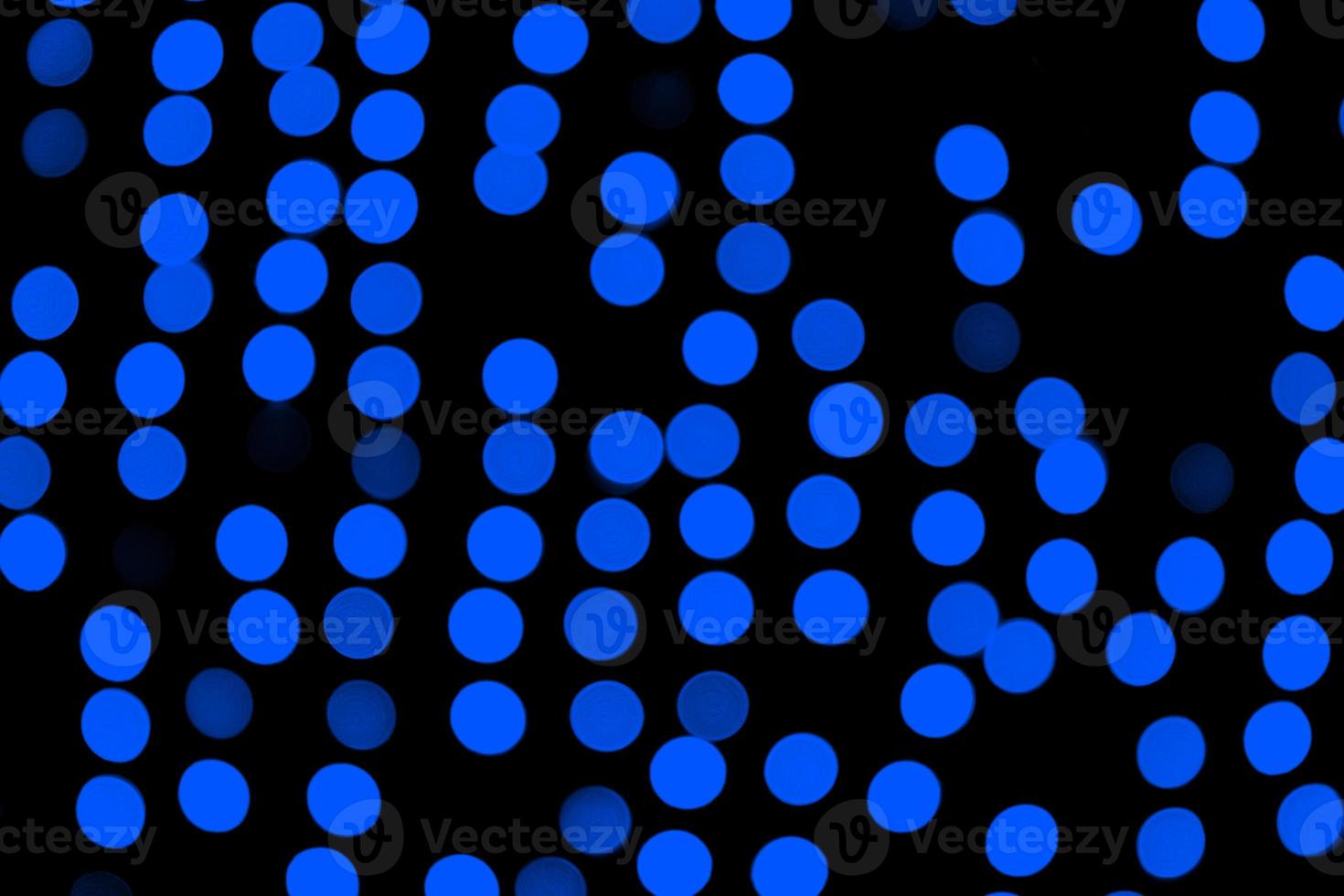 Unfocused abstract dark blue bokeh on black background. defocused and blurred many round light photo