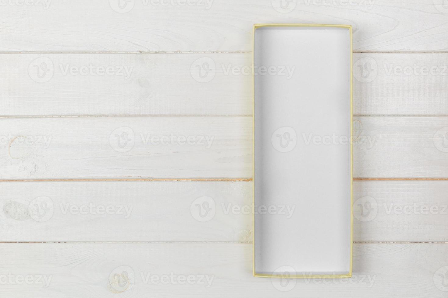 Opened empty cardboard box with cover on white wooden background. top view with copy space photo
