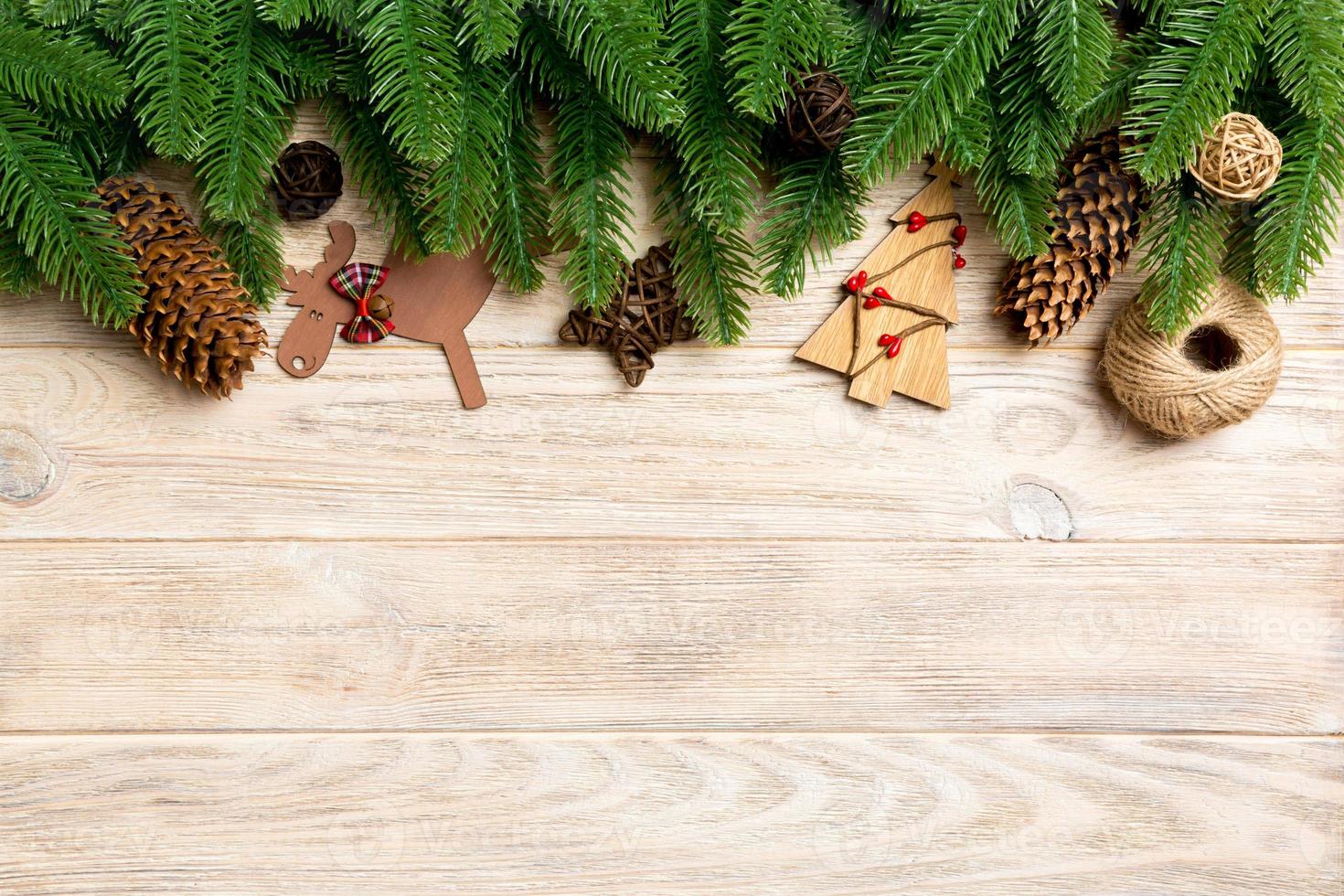 Top view of Christmas toys, decorations and fir tree branches on wooden background. New Year holiday concept with copy space photo