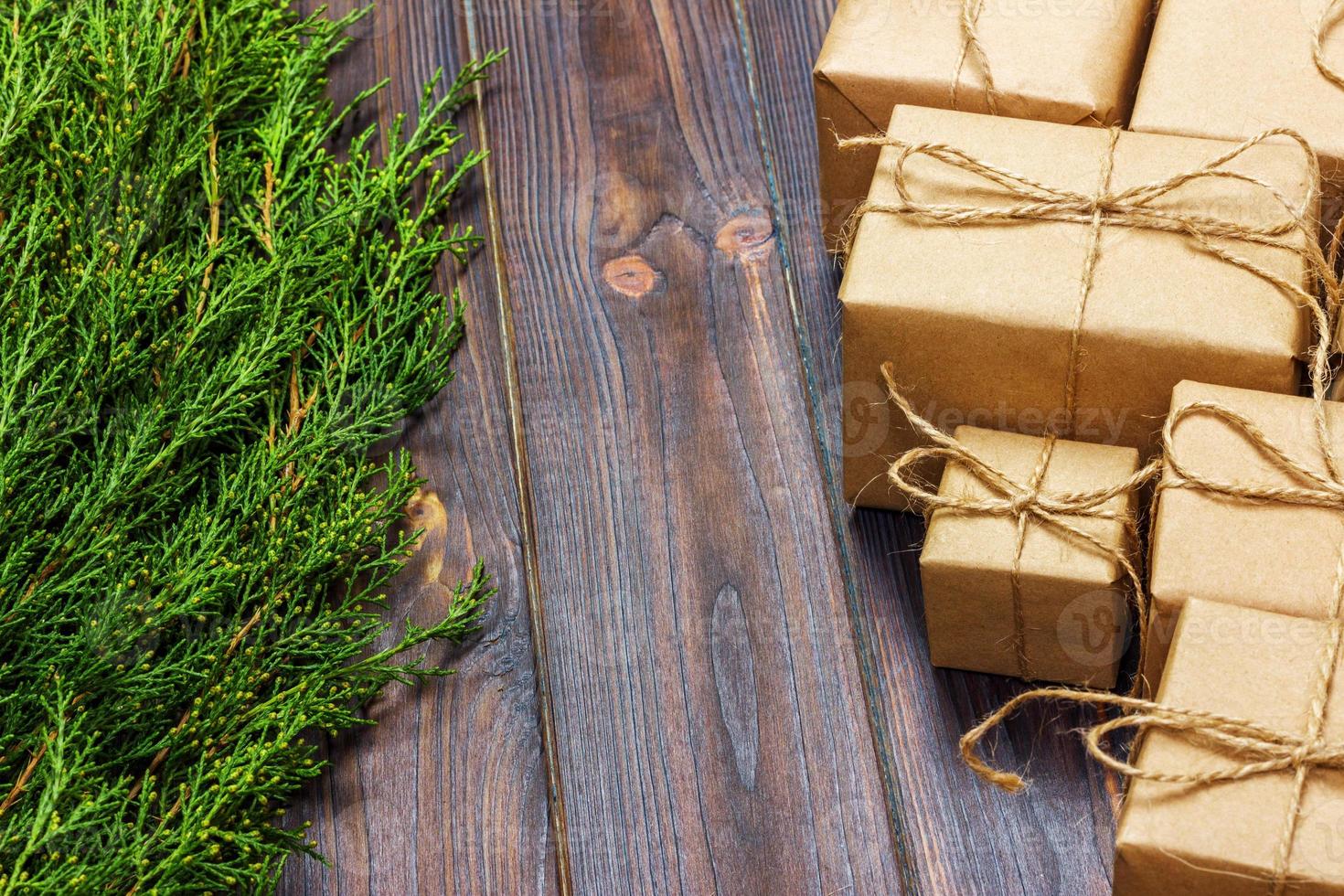 Christmas fir tree branches with gift box on dark rustic wooden background with copy space for text photo