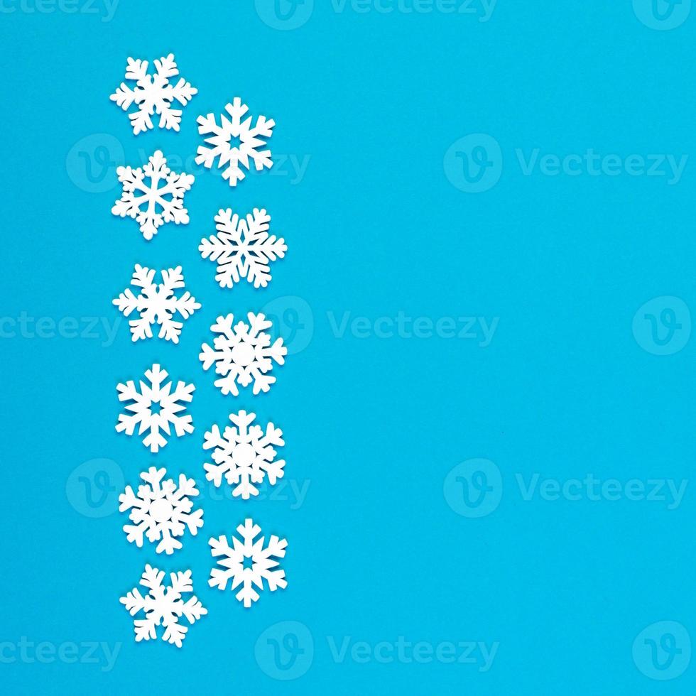 Top view of white snowflakes on colorful background. Winter weather concept with copy space. Merry Christmas concept photo